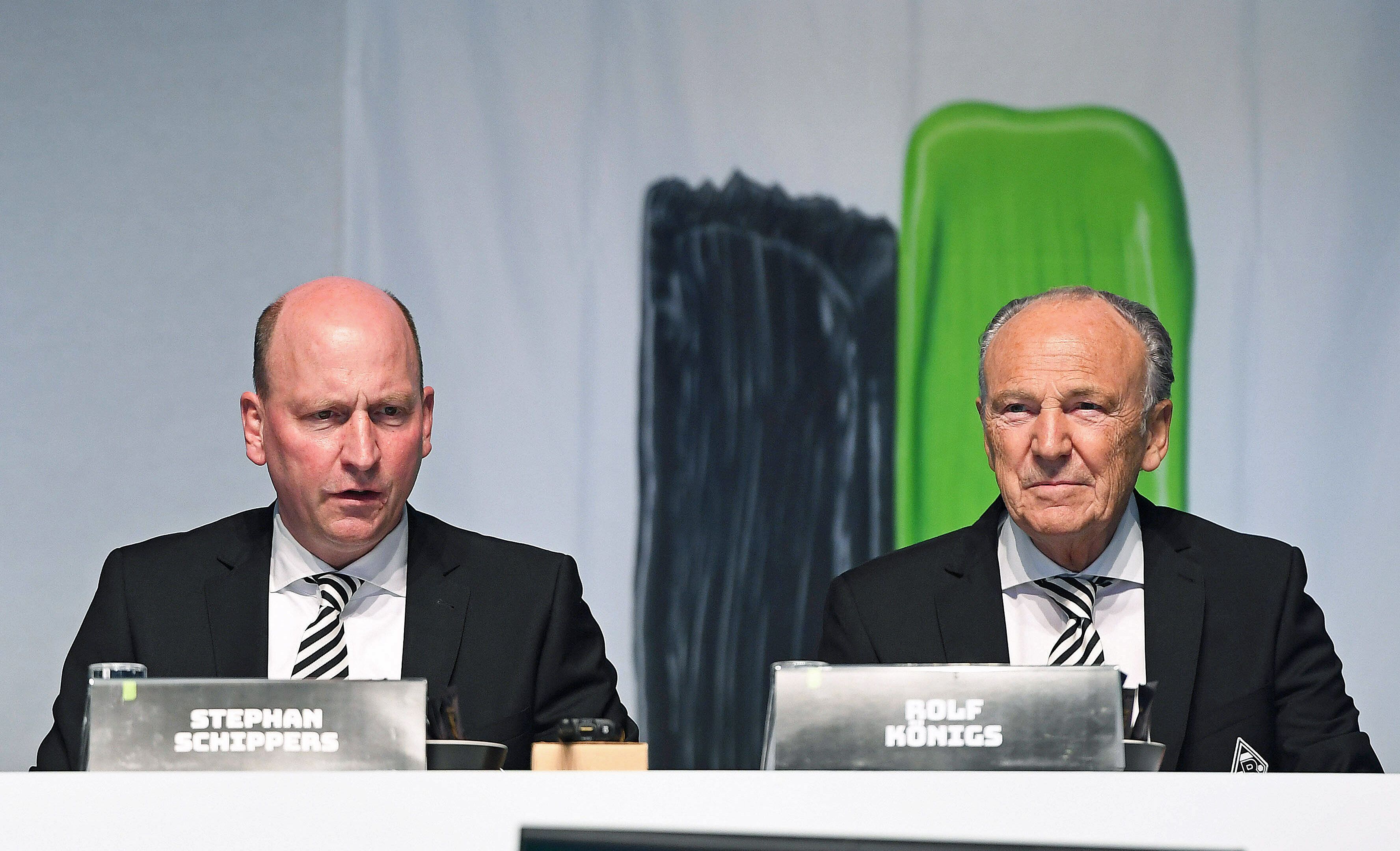 Präsident Rolf Königs (r.) und Geschäftsführer Stephan Schippers (l.), hier zu sehen bei der Mitgliederversammlung von Borussia Mönchengladbach am 10. August 2021. Königs und Schippers schauen auf einen Monitor.