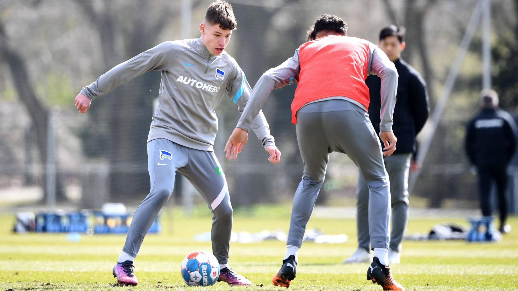 Lukas Ullrich (li.) steht möglicherweise vor einem Wechsel zu Borussia Mönchengladbach. Dieses Foto zeigt den 18-Jährigen am 11. April 2022 im Training von Hertha BSC. Ullrich hat den Ball am Fuß und geht in einen Zweikampf mit einem Mitspieler.