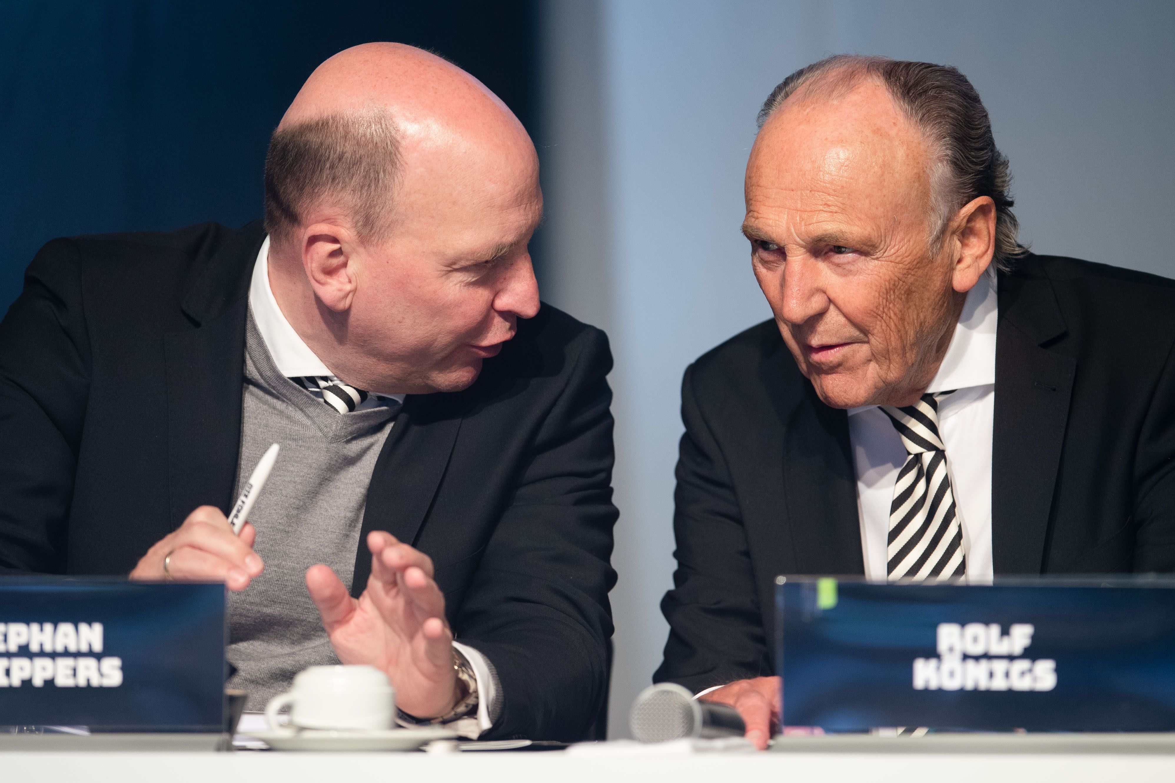 Die beiden mächtigsten Macher im Borussia-Park: Präsident Rolf Königs (r.) und Geschäftsführer Stephan Schippers (l.). Auf diesem Foto während der Mitgliederversammlung am 31. Mai 2022 im Borussia-Park zu sehen. Schippers beugt sich zu Königs rüber und sagt etwas in dessen Ohr.