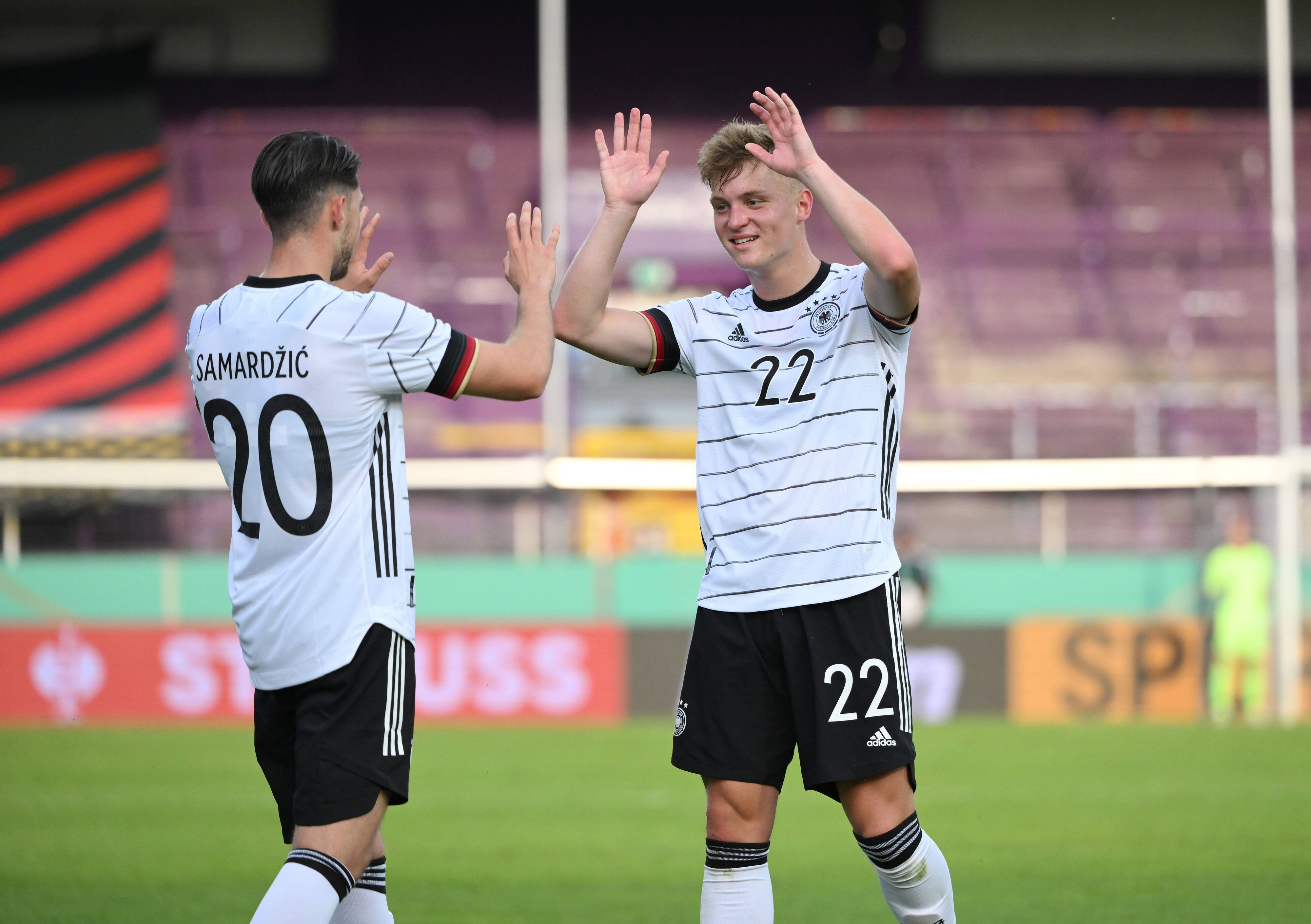 Luca Netz (re.) von Bundesligist Borussia Mönchengladbach hat sich am 3. Juni 2022 mit der Deutschen U21-Nationalmannschaft für die Europameisterschaft 2023 qualifiziert. Netz klatscht mit Lazar Samardzic ab und lächelt.
