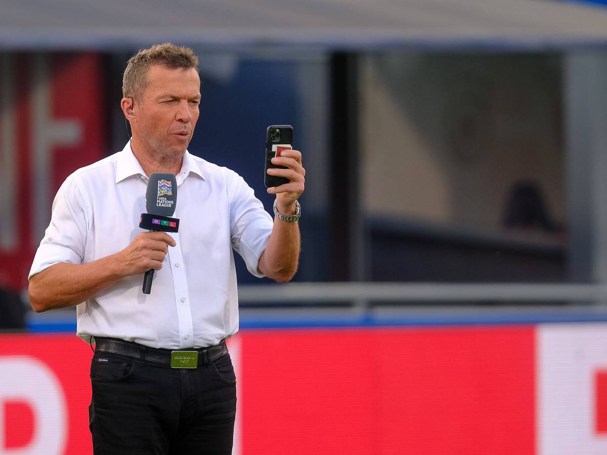 Ein Selfie muss sein! Weltmeister und TV-Experte Lothar Matthäus am 4. Juni 2022 in Bologna. Matthäus hält ein Smartphone in der linken Hand, in der rechten ein Mikrofon.