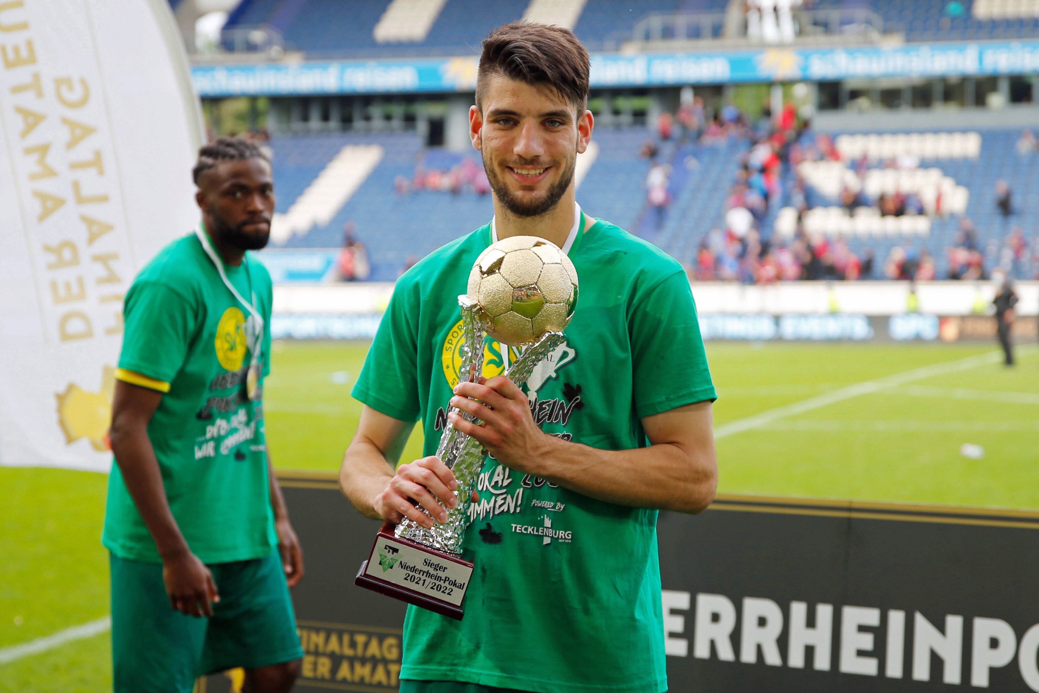 Er wechselt zu Borussia Mönchengladbach: Cagatay Kader, hier zu sehen am 21. Mai 2022 mit dem Niederrheinpokal in Duisburg, kommt vom SV Straelen in den Borussia-Park. Kader hält den Pokal in den Händen und lächelt in die Kamera.