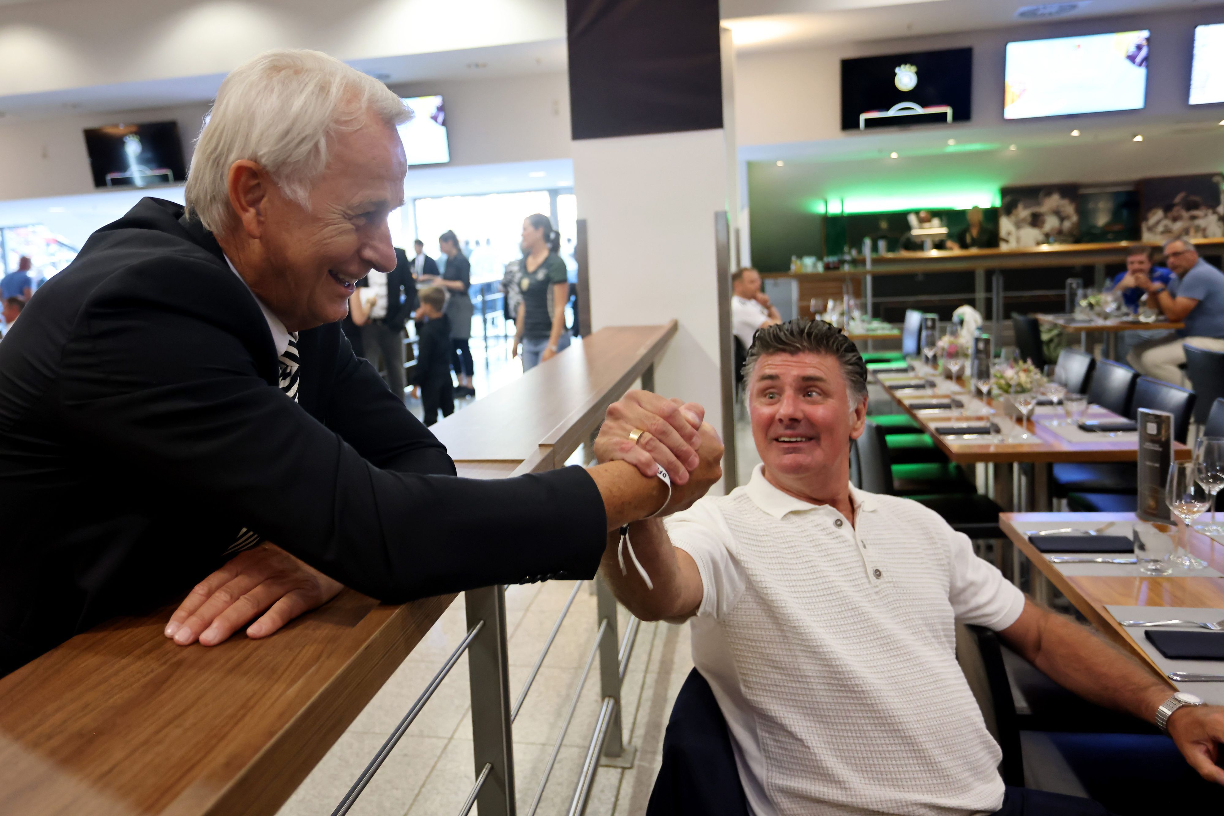 Rainer Bonhof (l.), Vize-Präsident von Borussia Mönchengladbach, und Wilfried Hannes (r.) begrüßen einander beim Treffen der ehemaligen Nationalspieler am Dienstagabend (14. Juni 2022) im Borussia-Park.