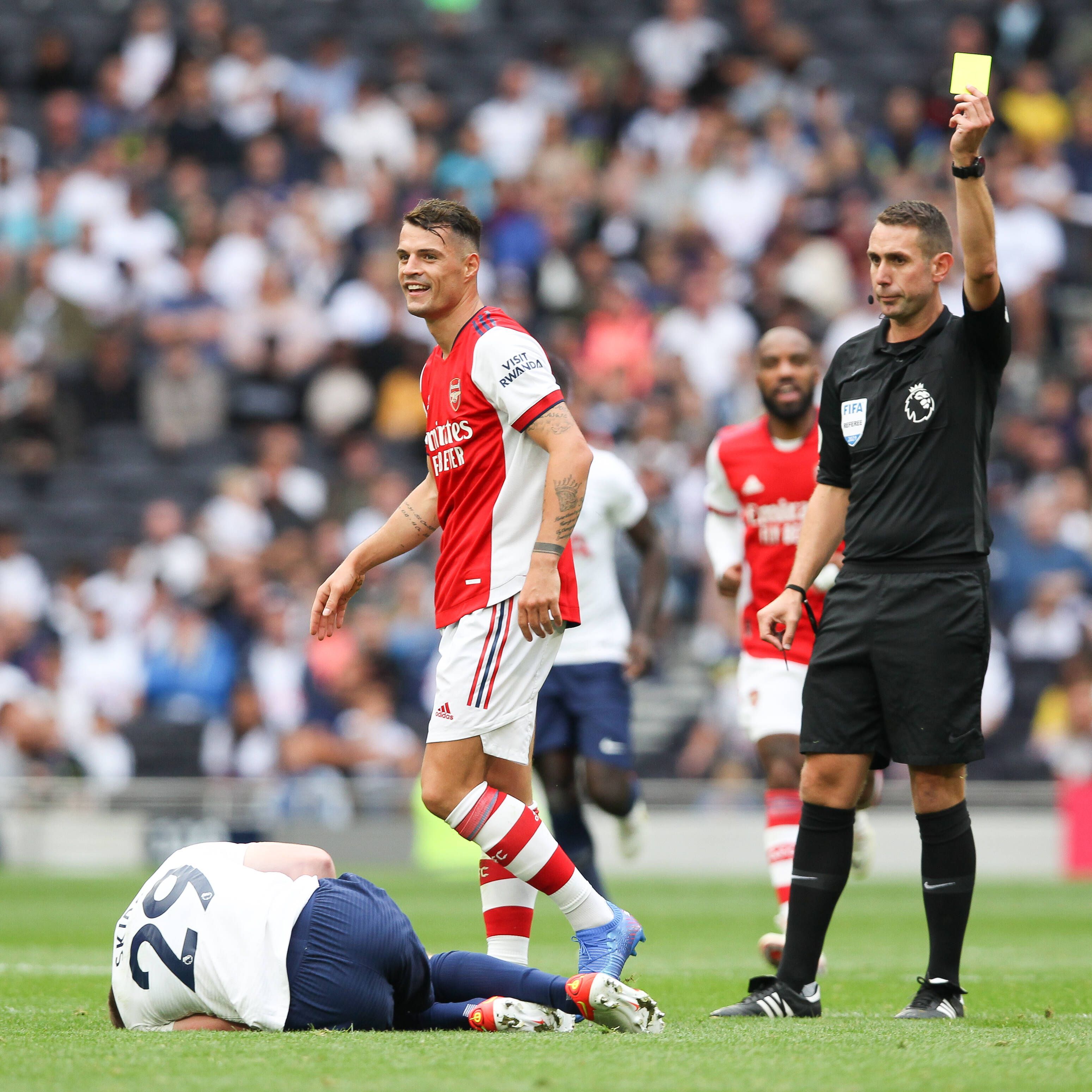 Granit Xhaka sieht eine Gelbe Karte, hier am 8. August 2021 bei einem Freundschaftsspiel von Arsenal gegen Tottenham. Xhaka wendet sich vom Schiedsrichter ab.