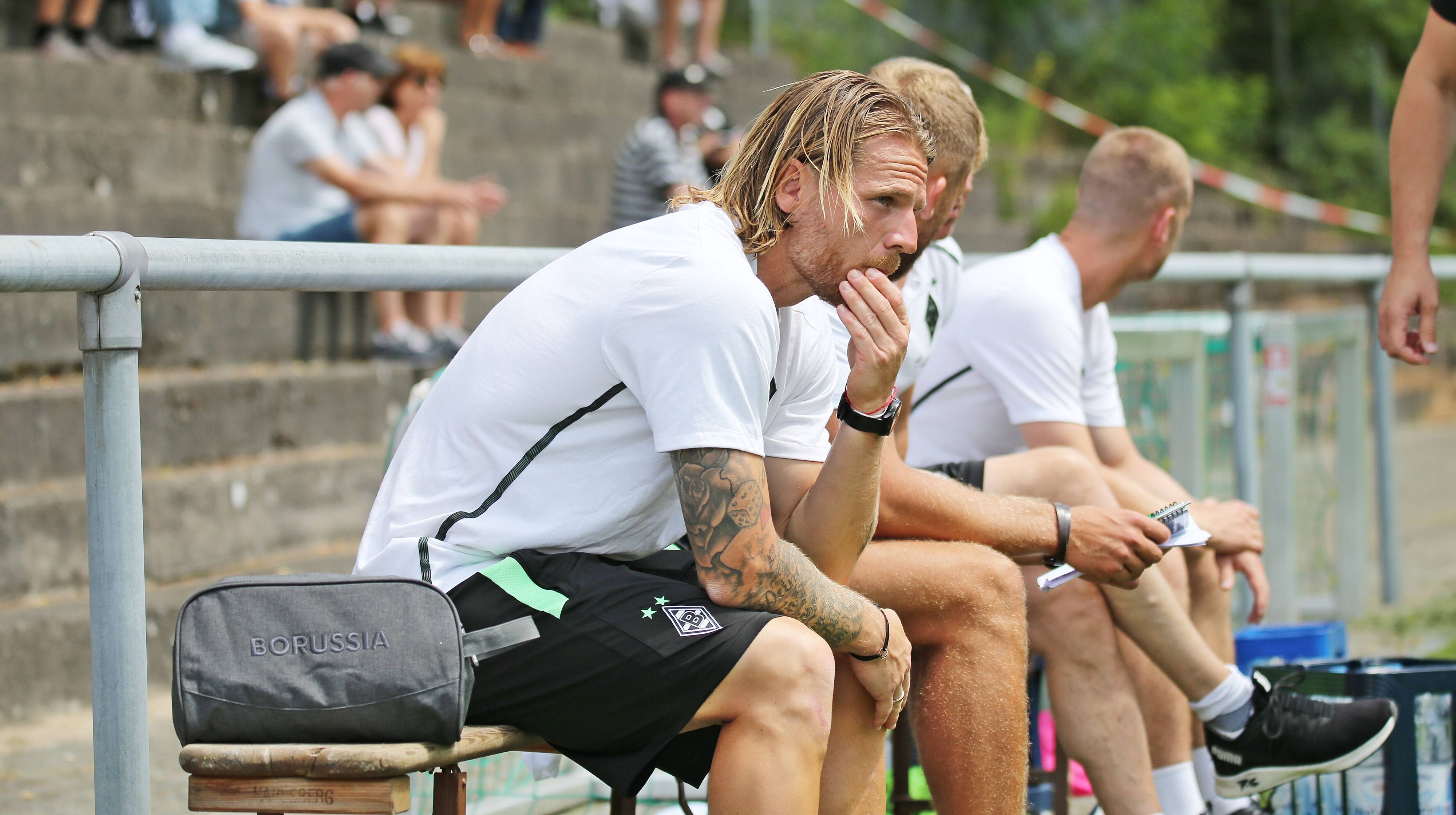 Eugen Polanski am 25. Juni 2022 als Trainer der U23 von Borussia Mönchengladbach gegen SV Elversberg. Polanski sitzt au einer Bank und stützt das Kinn auf den Armen auf.
