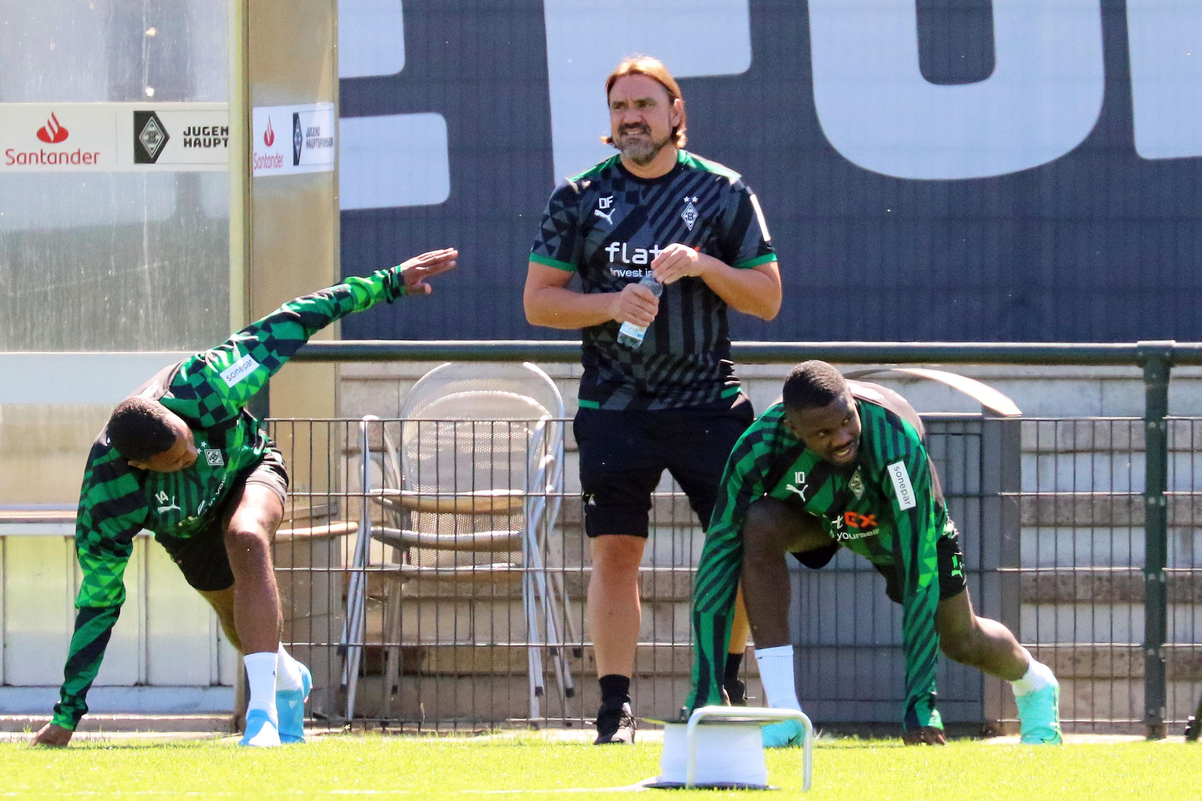 Gladbach-Trainer Daniel Farke schaut beim Training (28. Juni 2022) der Profis im Borussia-Park genau hin. Im Vordergrund sind Alassane Plea (l.) und Marcus Thuram (r.) zu sehen.