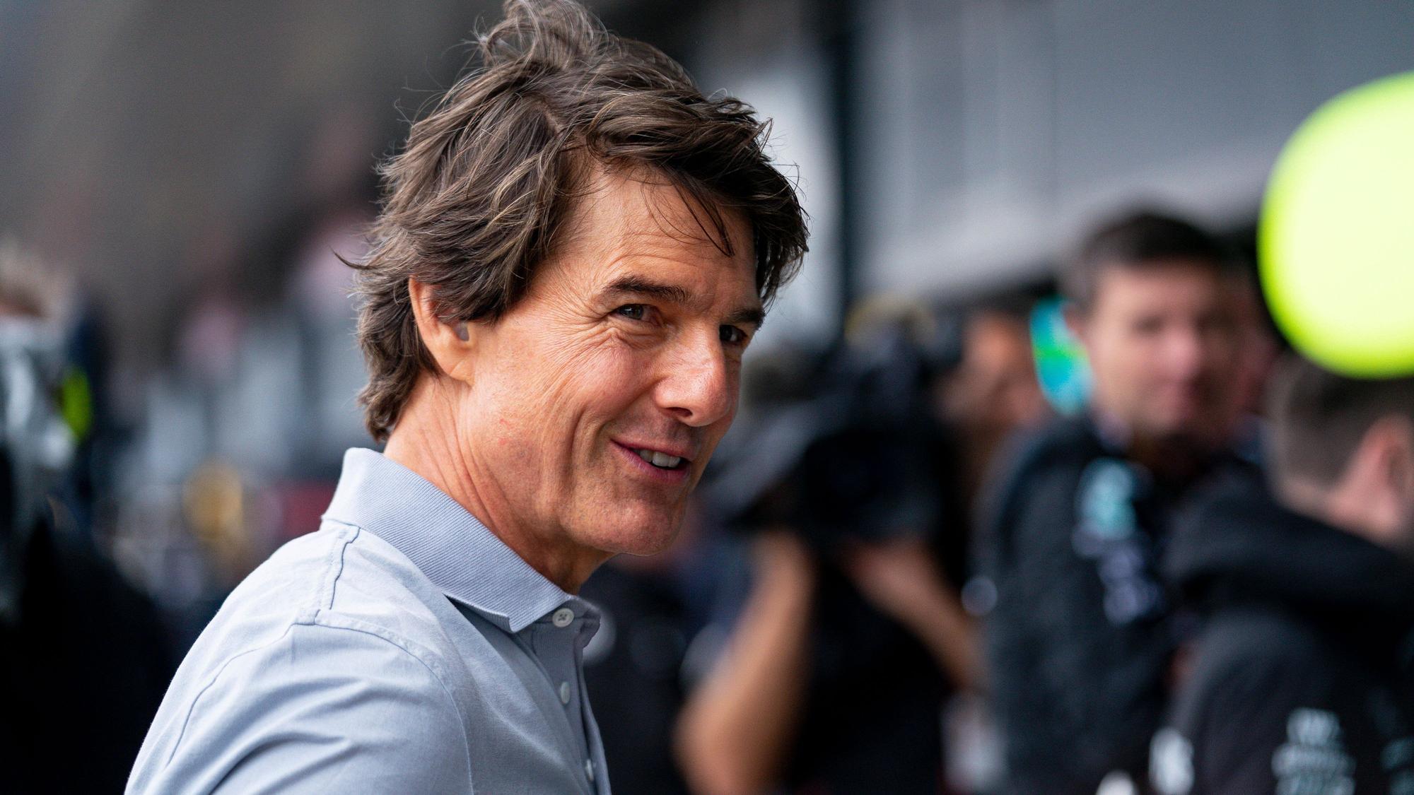 Hollywood-Star Tom Cruise hat beim Besuch des Formel-1-Rennens in Silverstone am Sonntag (3. Juli 2022) einen Profi von Borussia Mönchengladbach in der Boxengasse getroffen. Das Foto zeigt ihn Lächelnd.