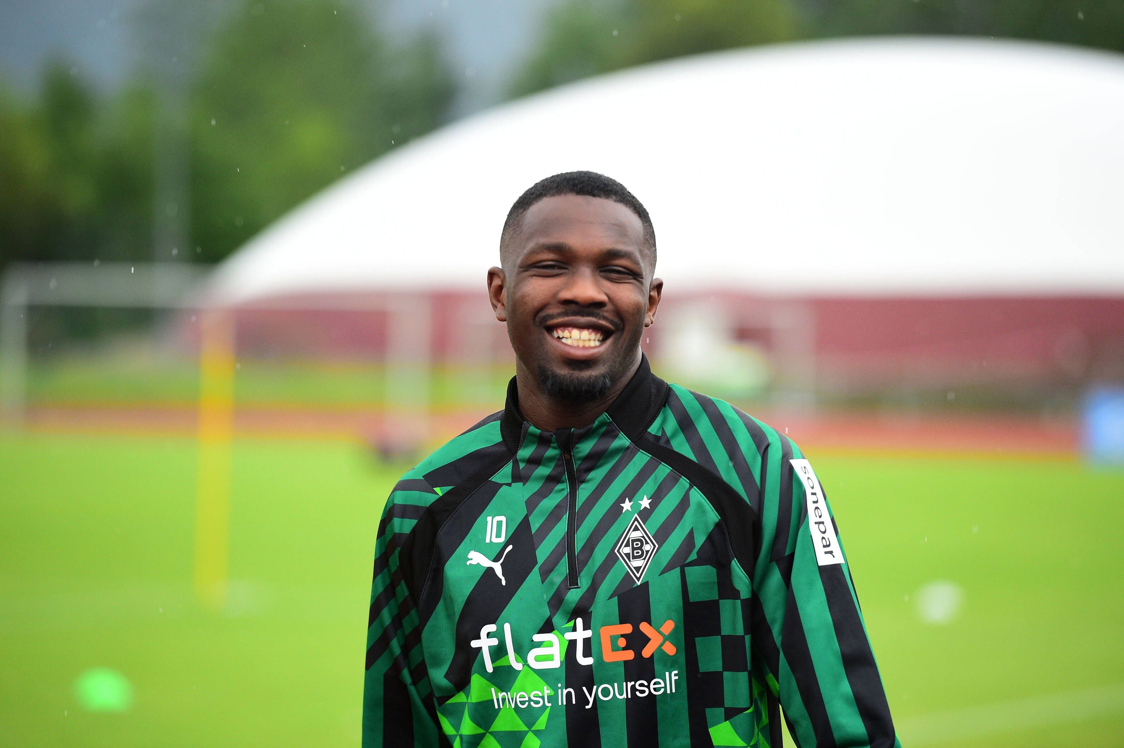 Borussia-Mönchengladbach-Star Marcus Thuram, hier am 4. Juli 2022 im Trainingslager der Borussia, könnte Gladbach wohl erhalten bleiben. Thuram lächelt in die Kamera.