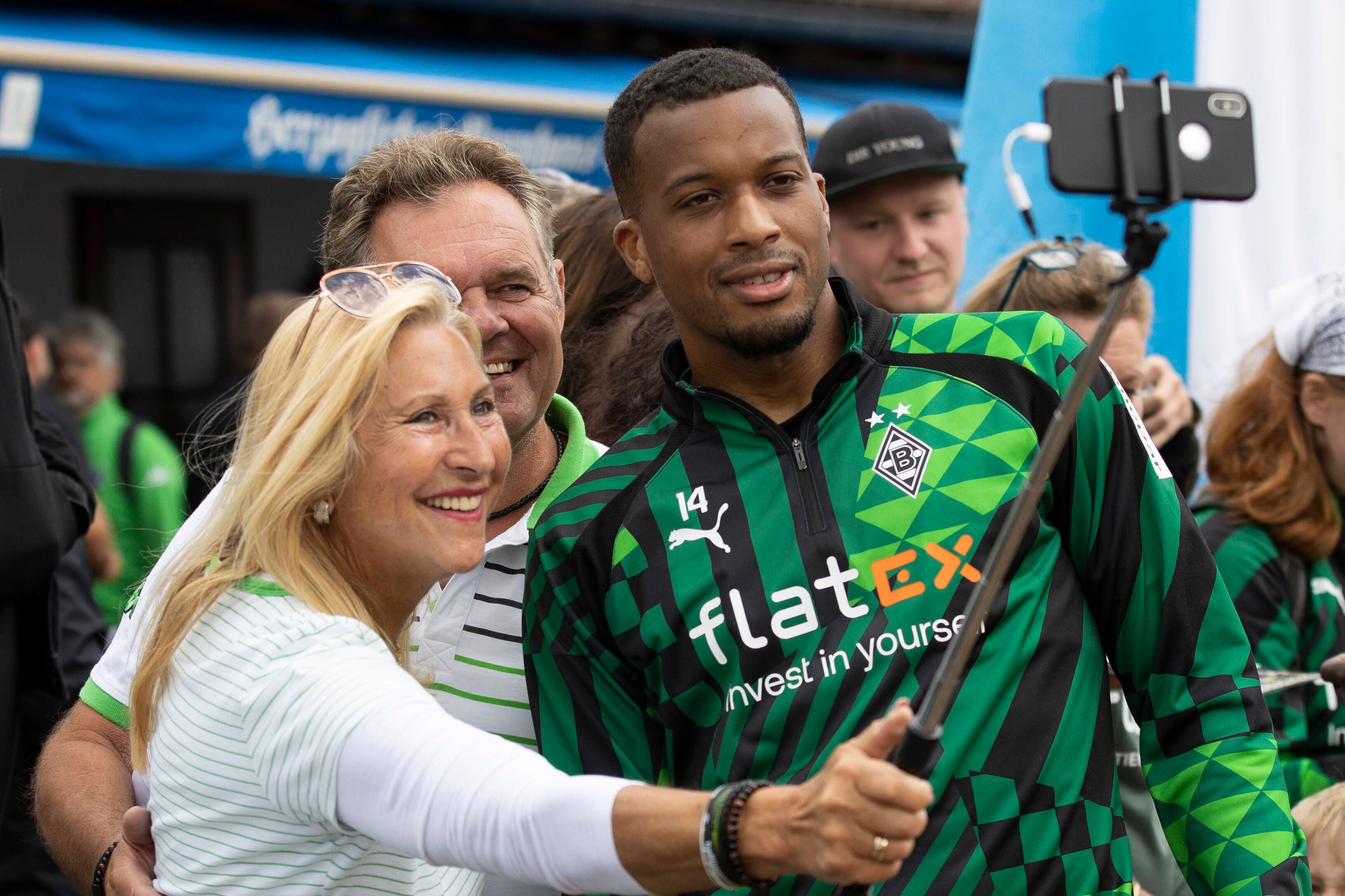 Eine Gemeinschaft! Gladbach-Star Alassane Plea (r.) nimmt sich im Trainingslager von Borussia Mönchengladbach am Tegernsee in Rottach-Egern Zeit für ein Selfie mit Fohlen-Fans. Dieses Foto stammt vom 8. Juli 2022. Plea lächelt in das Handy einer Zuschauerin, die einen Selfie-Stick für ihre Aufnahme benutzt.
