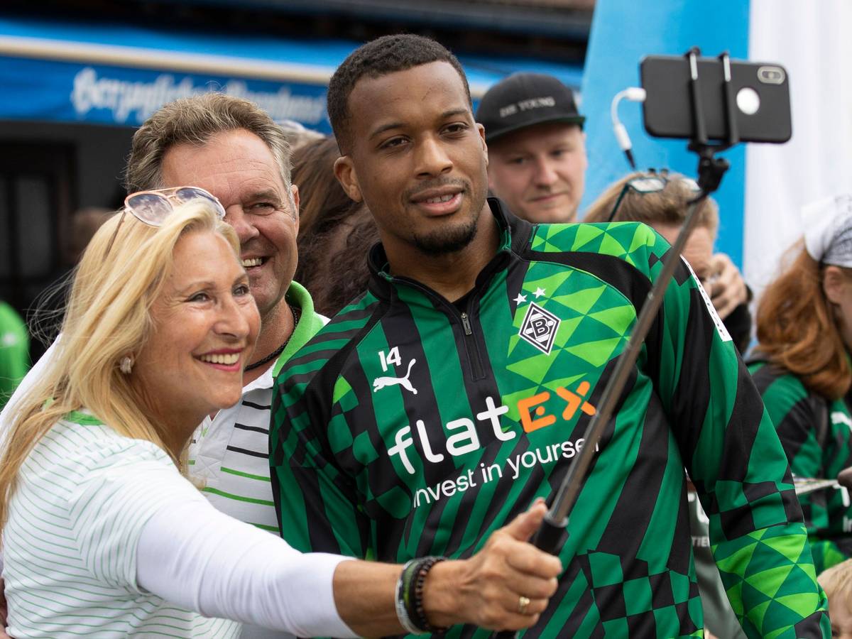 Eine Gemeinschaft! Gladbach-Star Alassane Plea (r.) nimmt sich im Trainingslager von Borussia Mönchengladbach am Tegernsee in Rottach-Egern Zeit für ein Selfie mit Fohlen-Fans. Dieses Foto stammt vom 8. Juli 2022. Plea lächelt in das Handy einer Zuschauerin, die einen Selfie-Stick für ihre Aufnahme benutzt.
