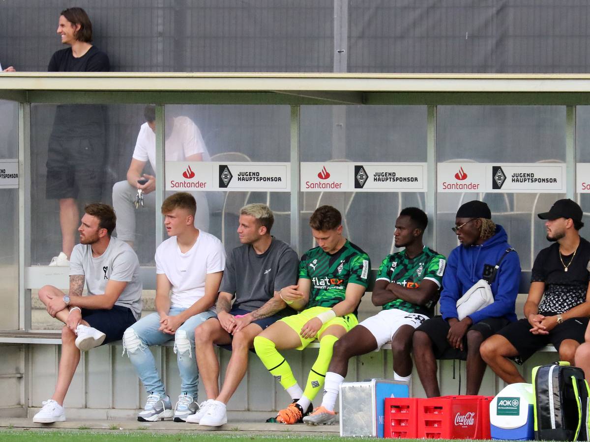 Prominent besetzte Zuschauerbank, mit unter anderem Ramy Bensebaini (2. v. r.) und Luca Netz (2. v. l.) im Rahmen des Testspiels zwischen Borussia Mönchengladbach und Viktoria Köln am 13. Juli 2022.