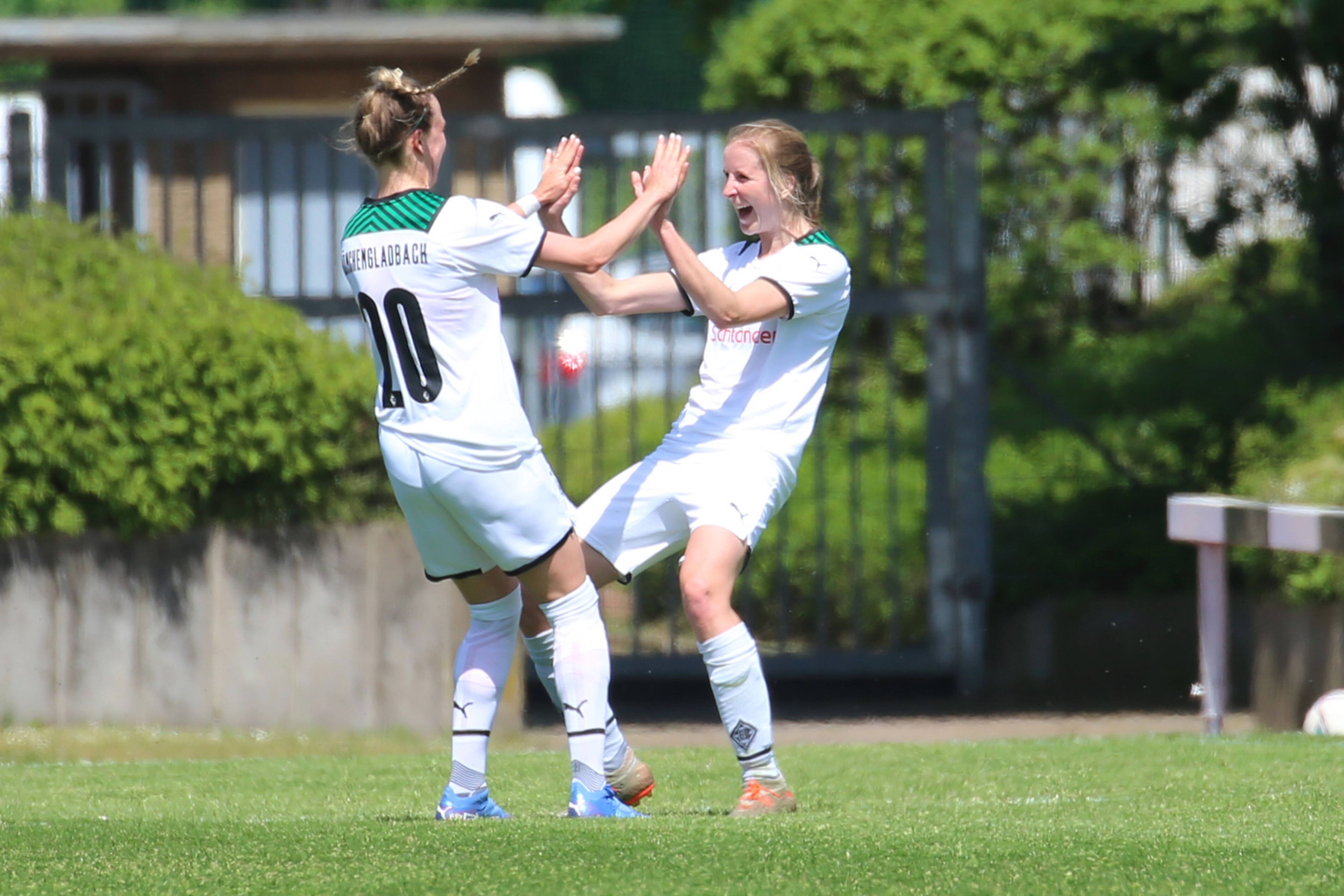 Die Gladbach-Spielerinnen (v.l.) Chantal Reinier Baghuis und Tabea Griss bejubeln einen Treffer im Regionalliga-Duell gegen SV Menden am 8. Mai 2022 im Rheydter Grenzlandstadion. Beide Spielerinnen klatschen sich ab.