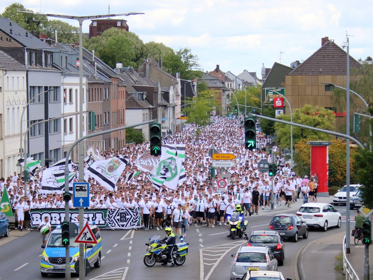 Tausende Menschen haben am Marsch der aktiven Fanszene von Borussia Mönchengladbach vor dem Bundesliga-Heimspiel am 6. August 2022 gegen die TSG Hoffenheim teilgenommen. Die Polizei regelt den Straßenverkehr.