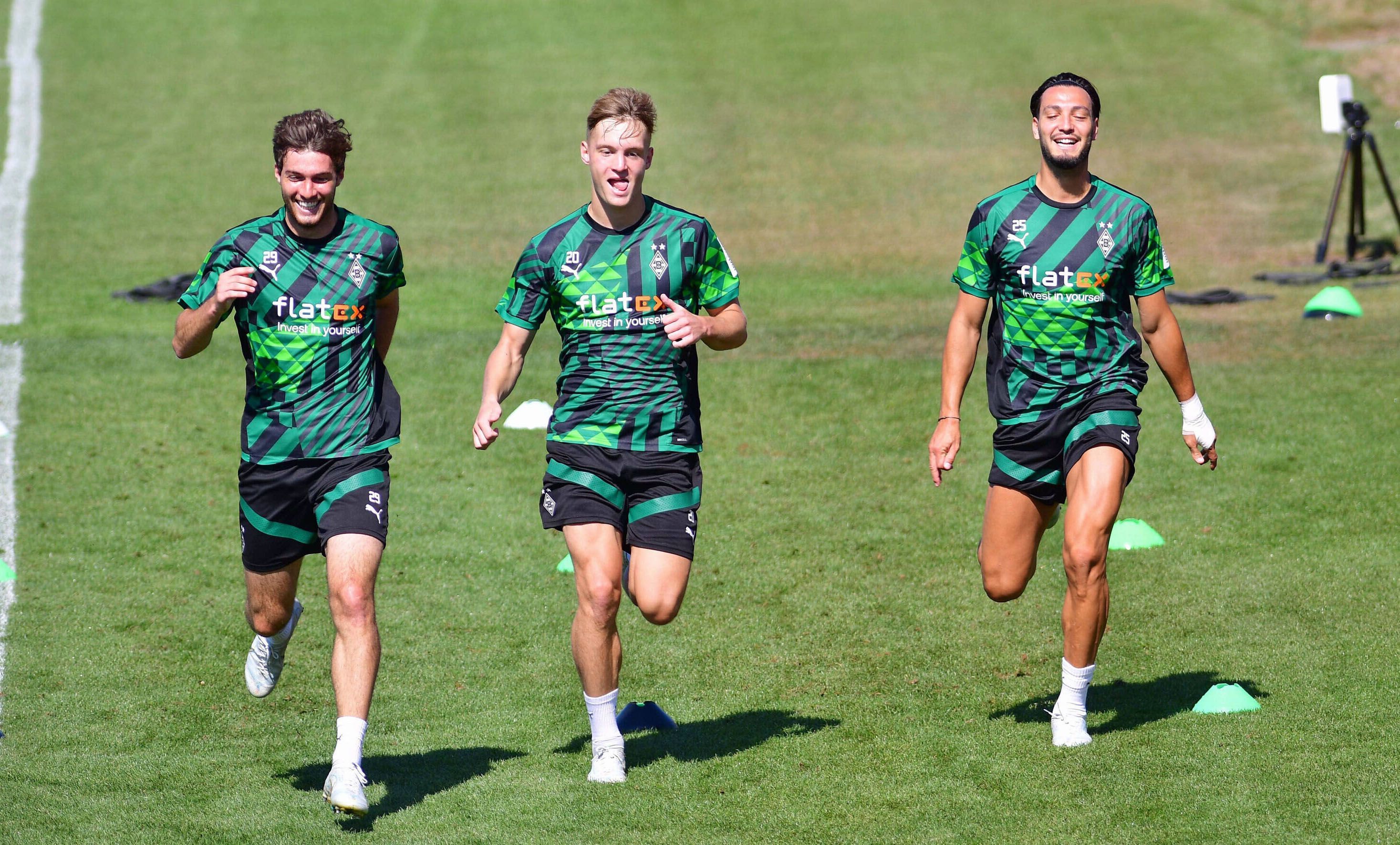 Gute Laune im Training von Borussia Mönchengladbach: Luca Netz (Mitte), Ramy Bensebaini (r.) und Joe Scally (l.) bei der Einheit am Mittwoch (10. August 2022) im Borussia-Park. Die drei Gladbach-Profis laufen über das Spielfeld.
