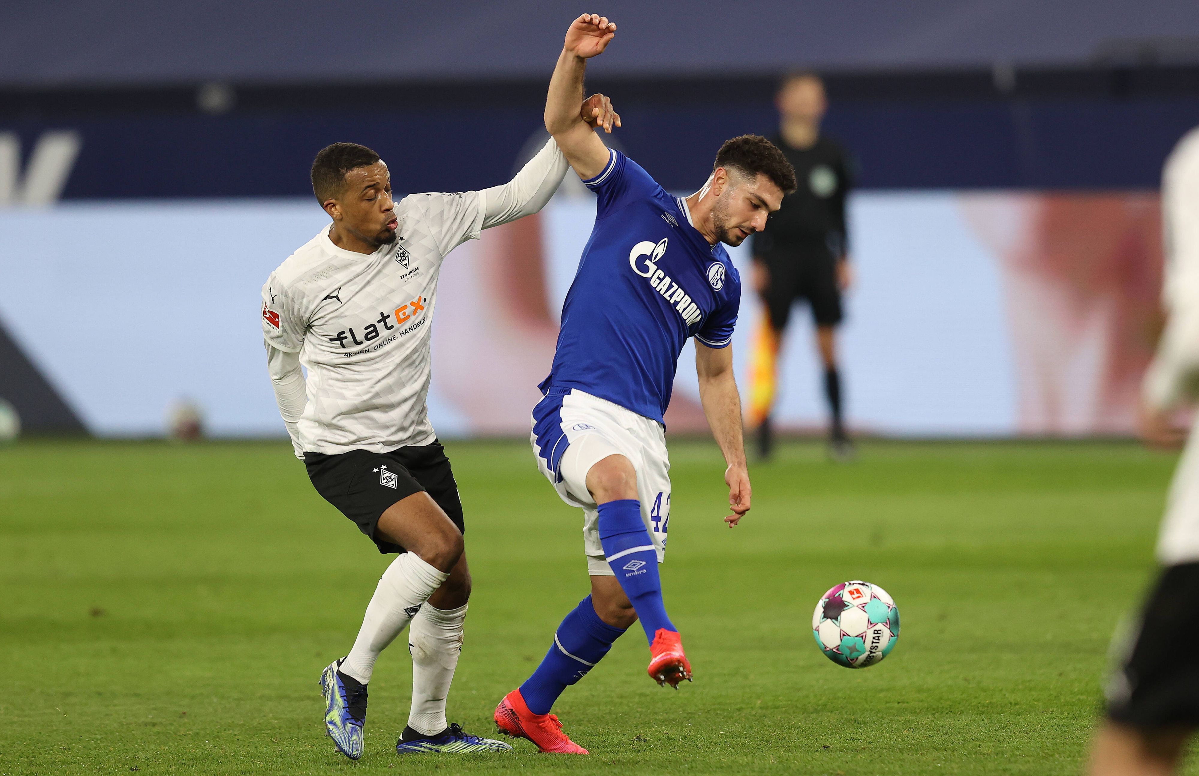 Borussia Mönchengladbach tritt am Samstag (13. August 2022) am 2. Bundesliga-Spieltag beim FC Schalke 04 an. Das Foto zeigt Gladbachs Alassane Plea (l.) und Schalkes Kerim Calhanoglu (r.) im vergangenen Duell am 20. März 2021.