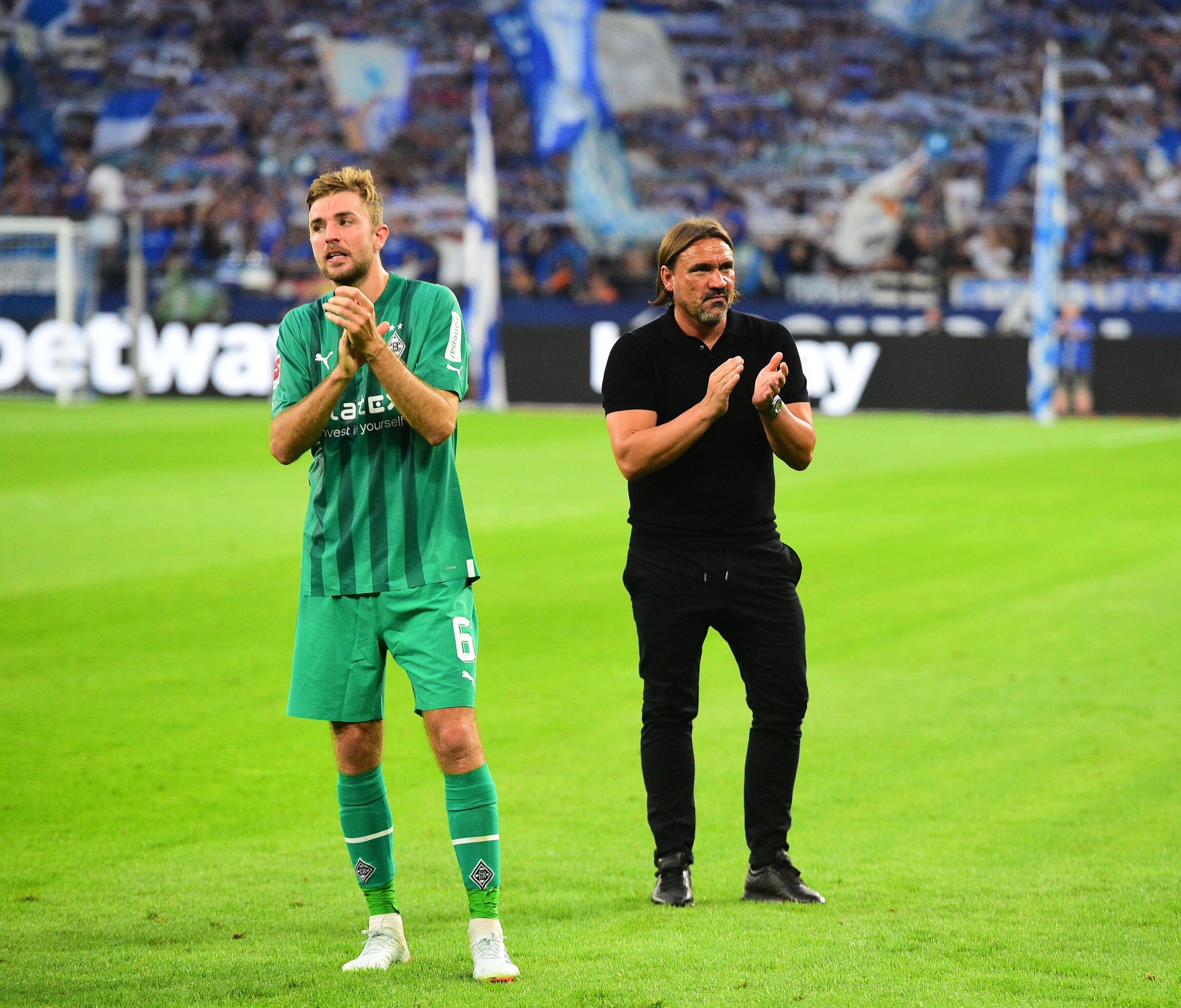 Gladbach-Profi Christoph Kramer (l.) und Trainer Daniel Farke (r.) nach dem Unentschieden von Fußball-Bundesligist Borussia Mönchengladbach beim FC Schalke 04 am 13. August 2022. Die beiden klatschen in die Hände.
