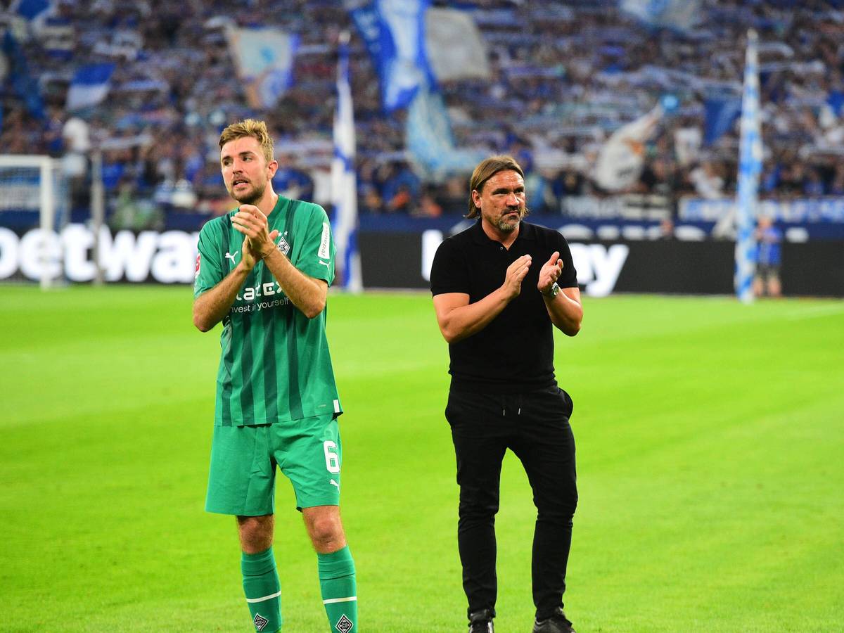 Gladbach-Profi Christoph Kramer (l.) und Trainer Daniel Farke (r.) nach dem Unentschieden von Fußball-Bundesligist Borussia Mönchengladbach beim FC Schalke 04 am 13. August 2022. Die beiden klatschen in die Hände.
