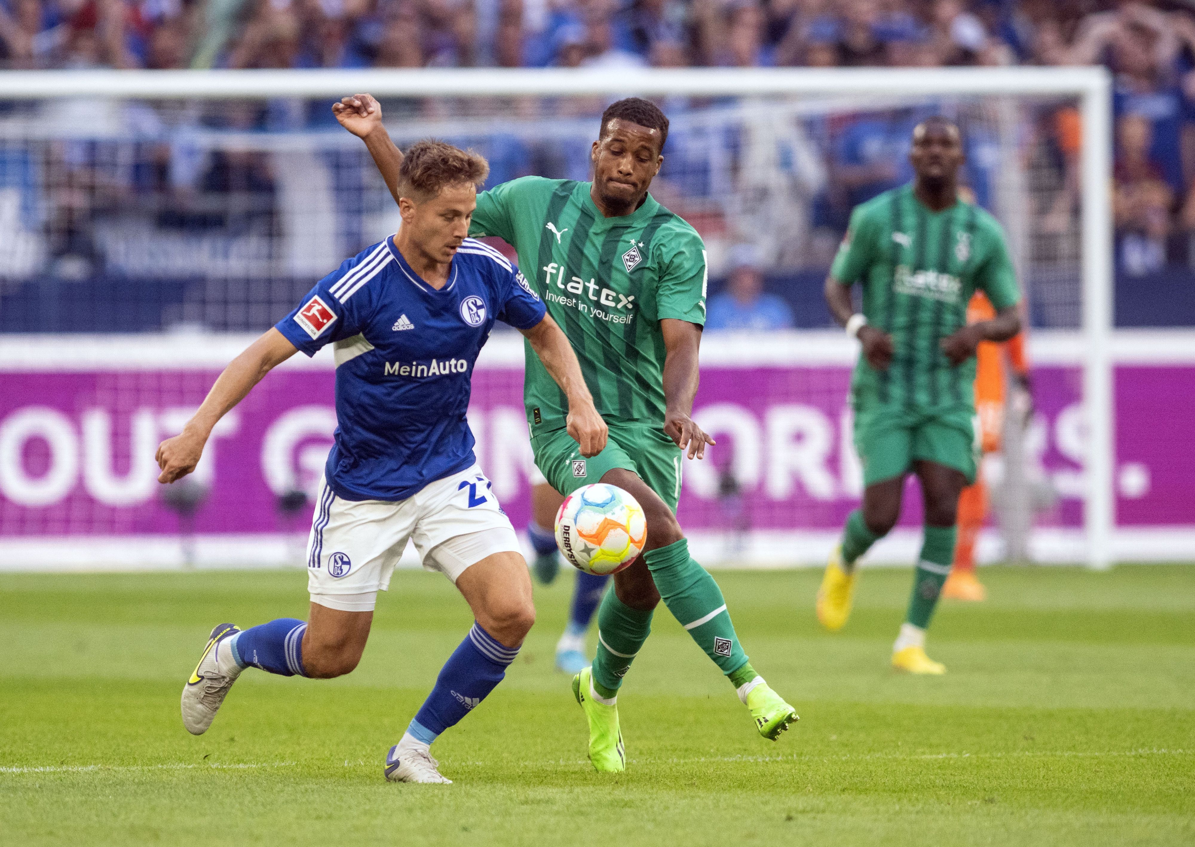 Borussia Mönchengladbach hat am Samstag (13. August 2022) beim FC Schalke 04 2:2 gespielt. Das Foto zeigt Gladbachs Alassane Plea (r.) im Zweikampf mit Schalkes Cédric Brunner (l.).