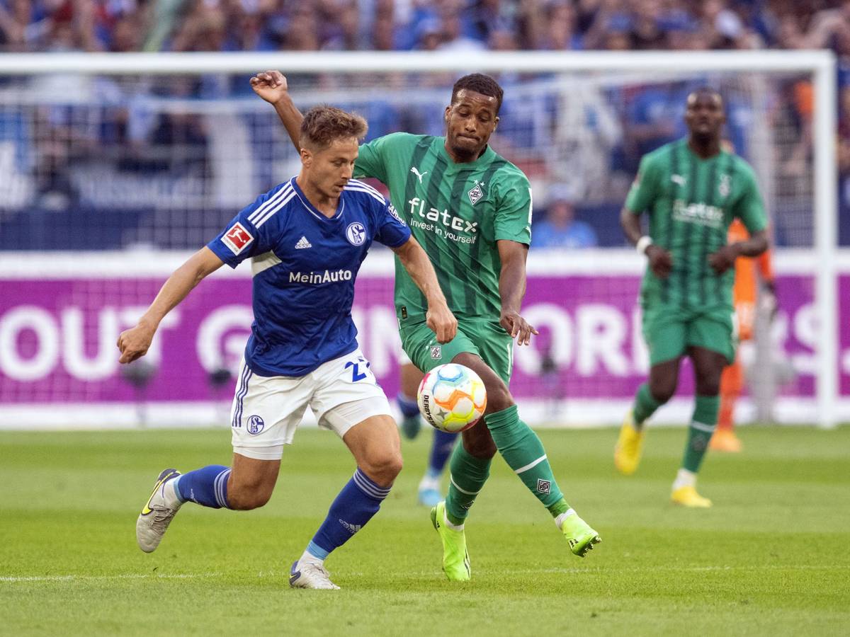 Borussia Mönchengladbach hat am Samstag (13. August 2022) beim FC Schalke 04 2:2 gespielt. Das Foto zeigt Gladbachs Alassane Plea (r.) im Zweikampf mit Schalkes Cédric Brunner (l.).