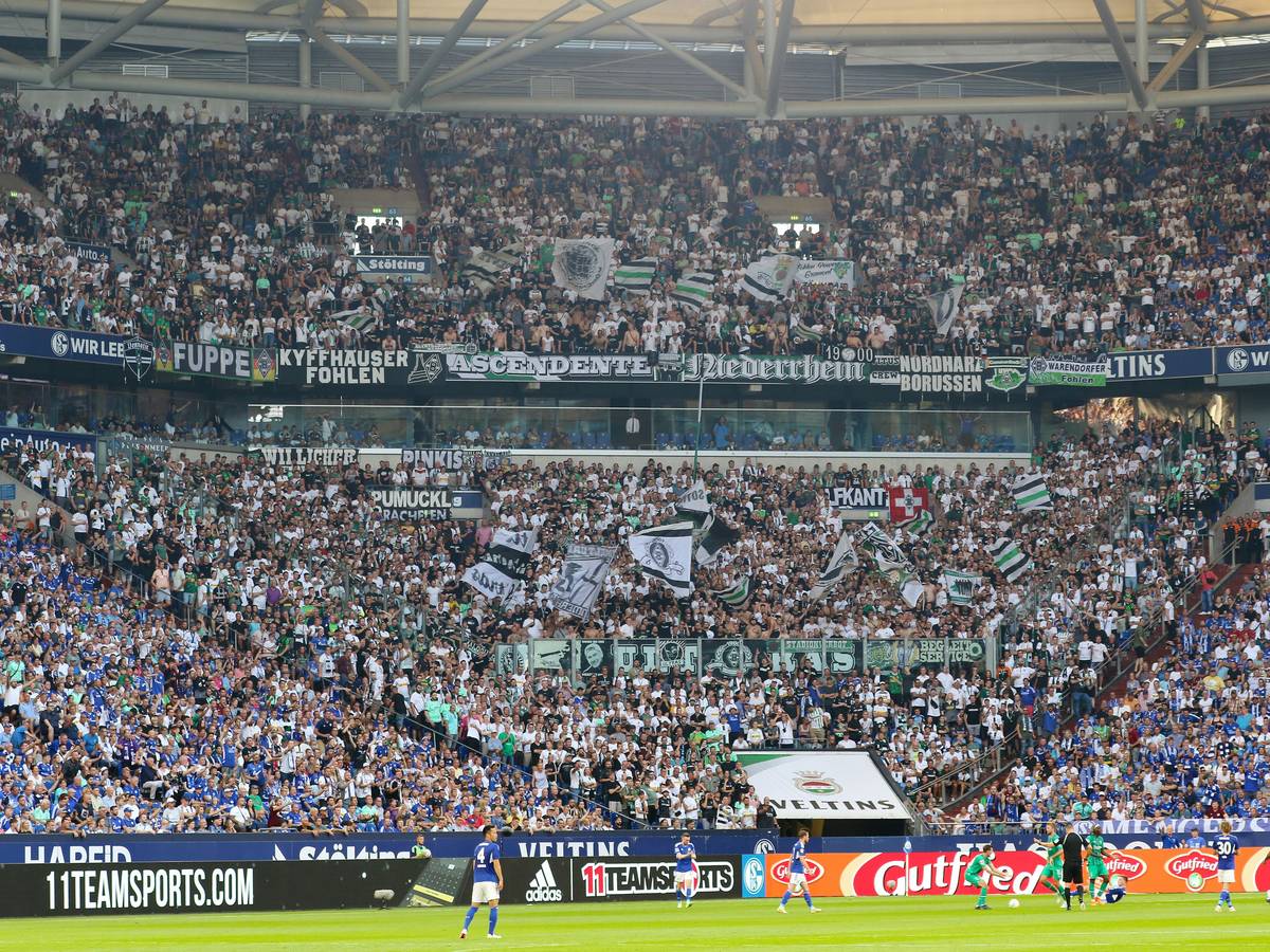 Tausende Fans von Fußball-Bundesligist Borussia Mönchengladbach im Gästeblock der Arena während des Tospiels beim FC Schalke 04 am 13. August 2022. Zu sehen sind Fahnen und Banner.