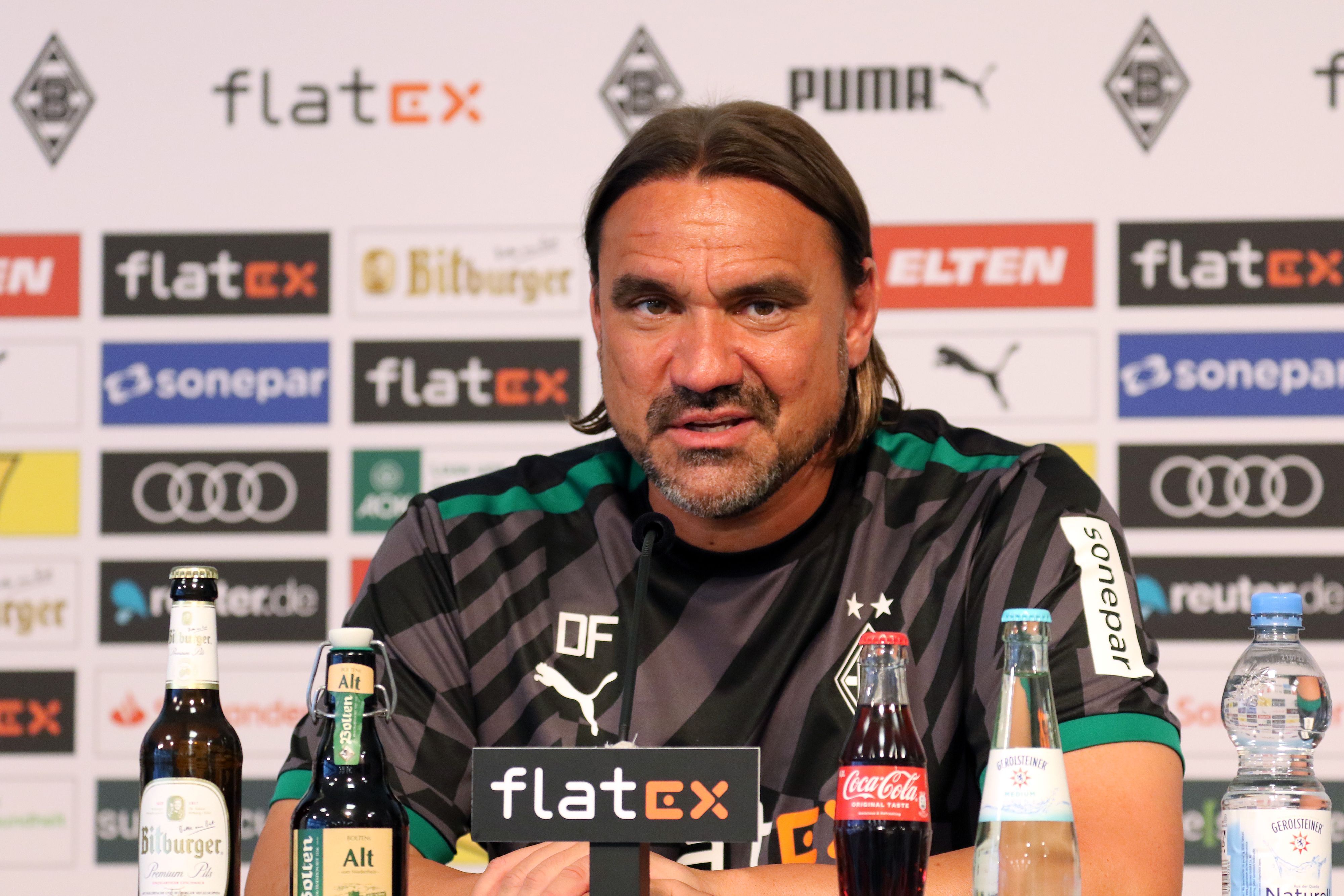 Daniel Farke, Trainer von Borussia Mönchengladbach, bei einer Pressekonferenz im Borussia-Park am 11. August 2022. Farke spricht in ein Mikrofon.