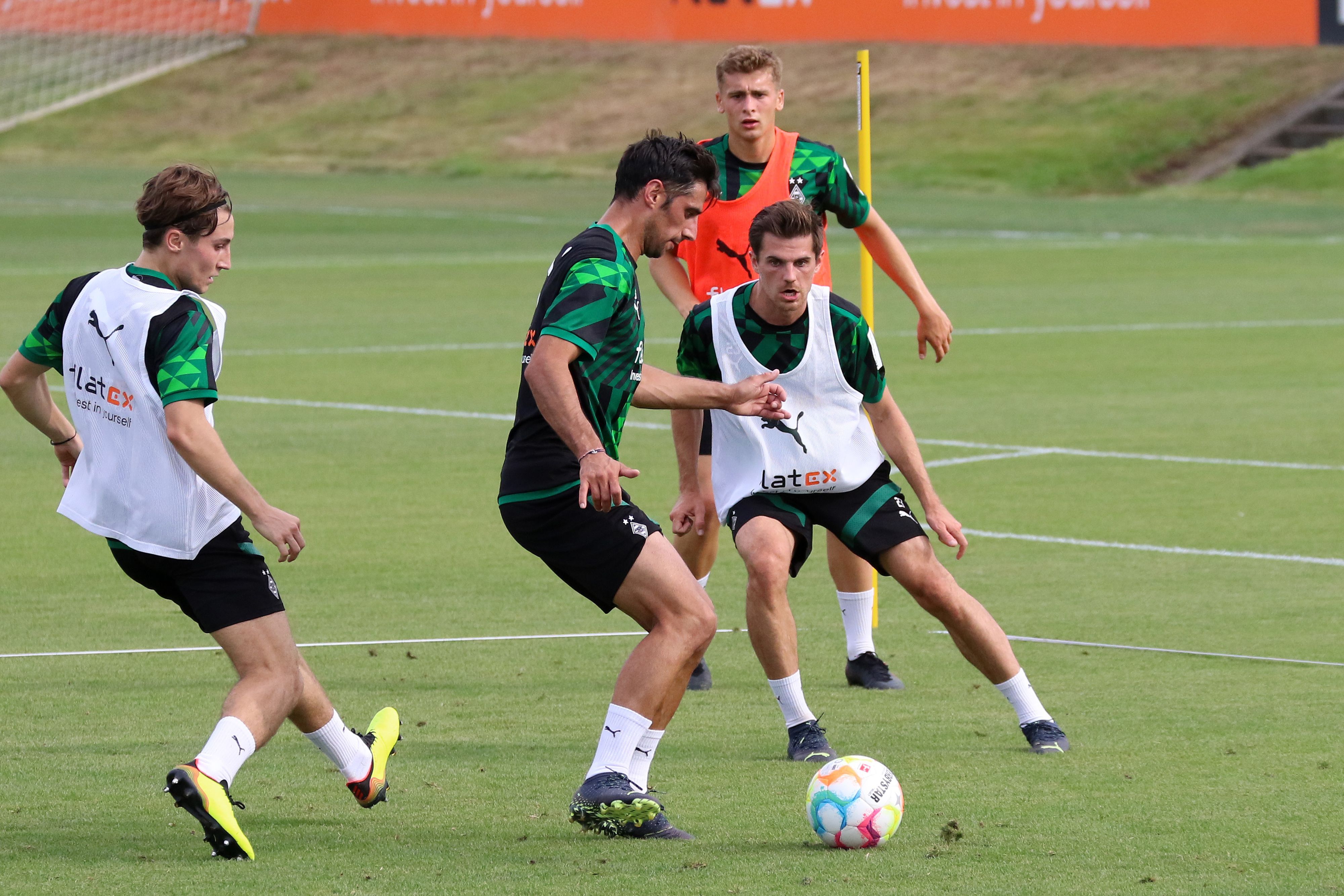 Gladbach-Kapitän Lars Stindl (2.v.l.) mischt im Mannschaftstraining wieder voll mit und könnte nach seiner Muskel-Verletzung für das Bundesliga-Duell gegen Hertha BSC (19. August 2022) wieder eine Kader-Option sein. Auf diesem Foto ist Stindl am 16. August zu sehen. Er spielt den Ball.