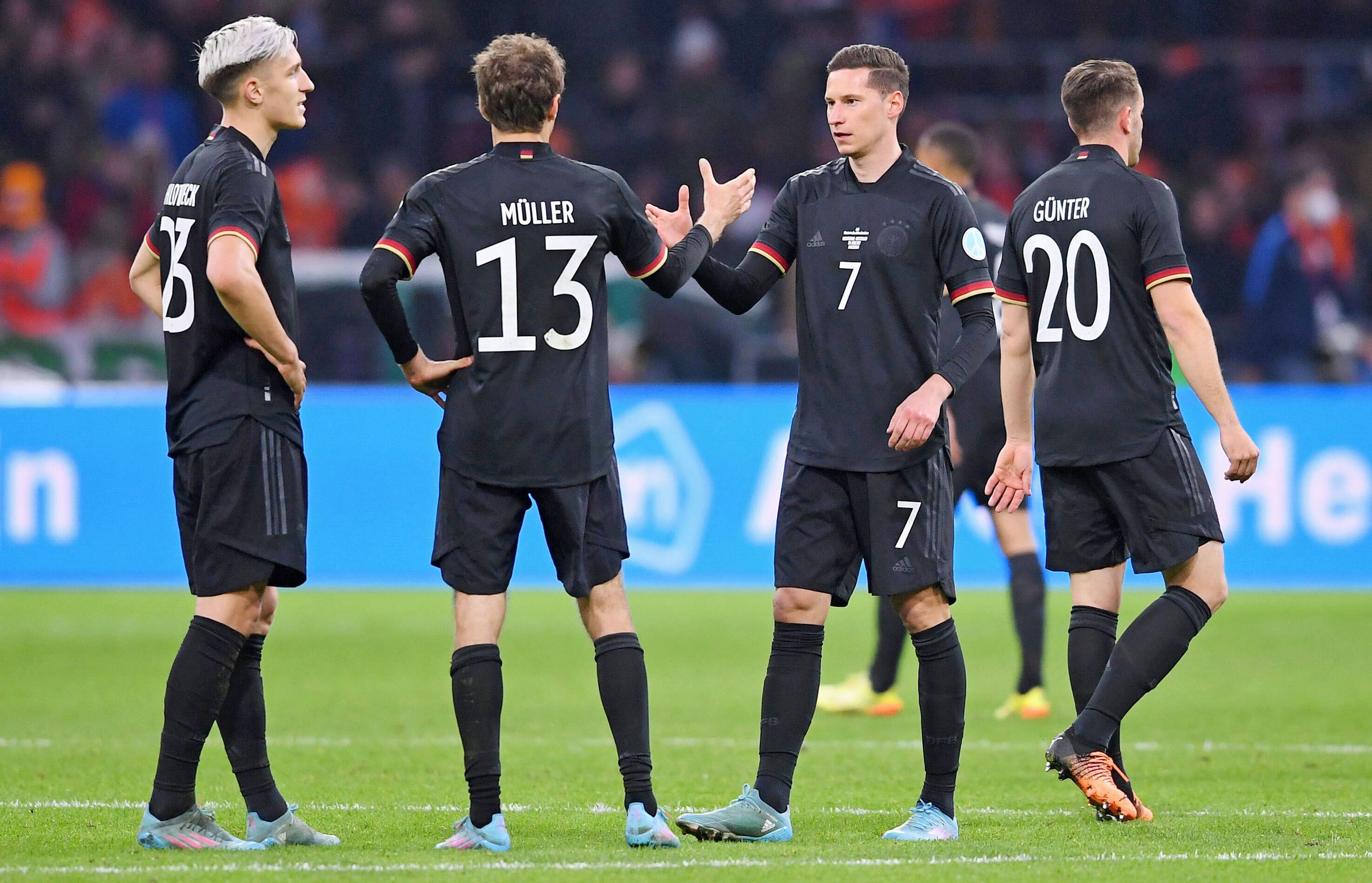 Er soll Thema in Gladbach sein: DFB-Nationalspieler Julian Draxler (2.v.r.) klatscht Thomas Müller (2.v.l.) beim Länderspiel gegen die Niederlande am 29. März 2022 in Amsterdam ab. Die deutschen Spieler tragen schwarze Trikots.