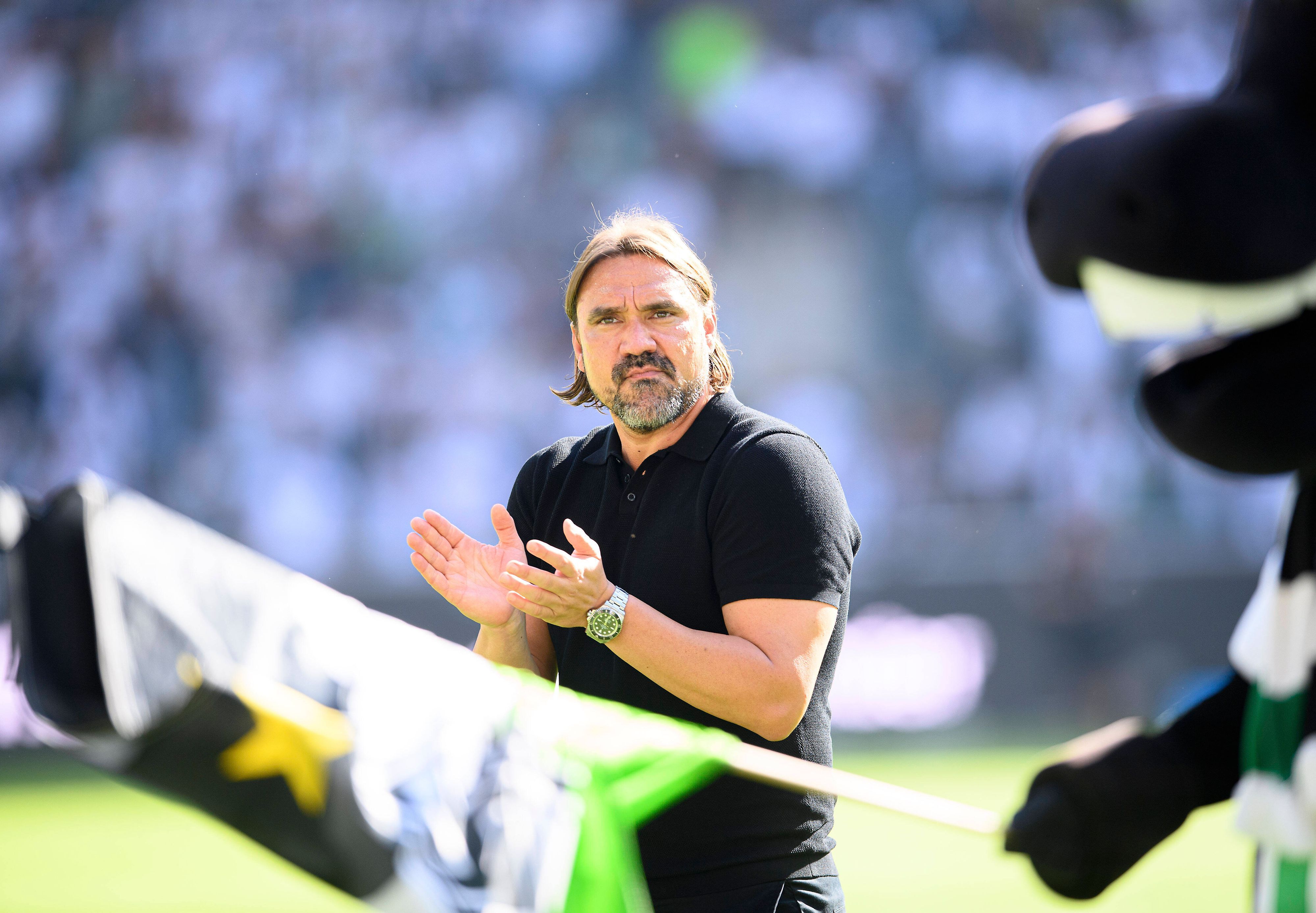 Gladbach-Trainer Daniel Farke. Auf diesem Bild ist der 45-Jährige am 6. August 2022 im Borussia-Park zu sehen. Im Vordergrund schwenkt Borussia-Maskottchen Jünter eine Fahne in den Vereinsfarben.