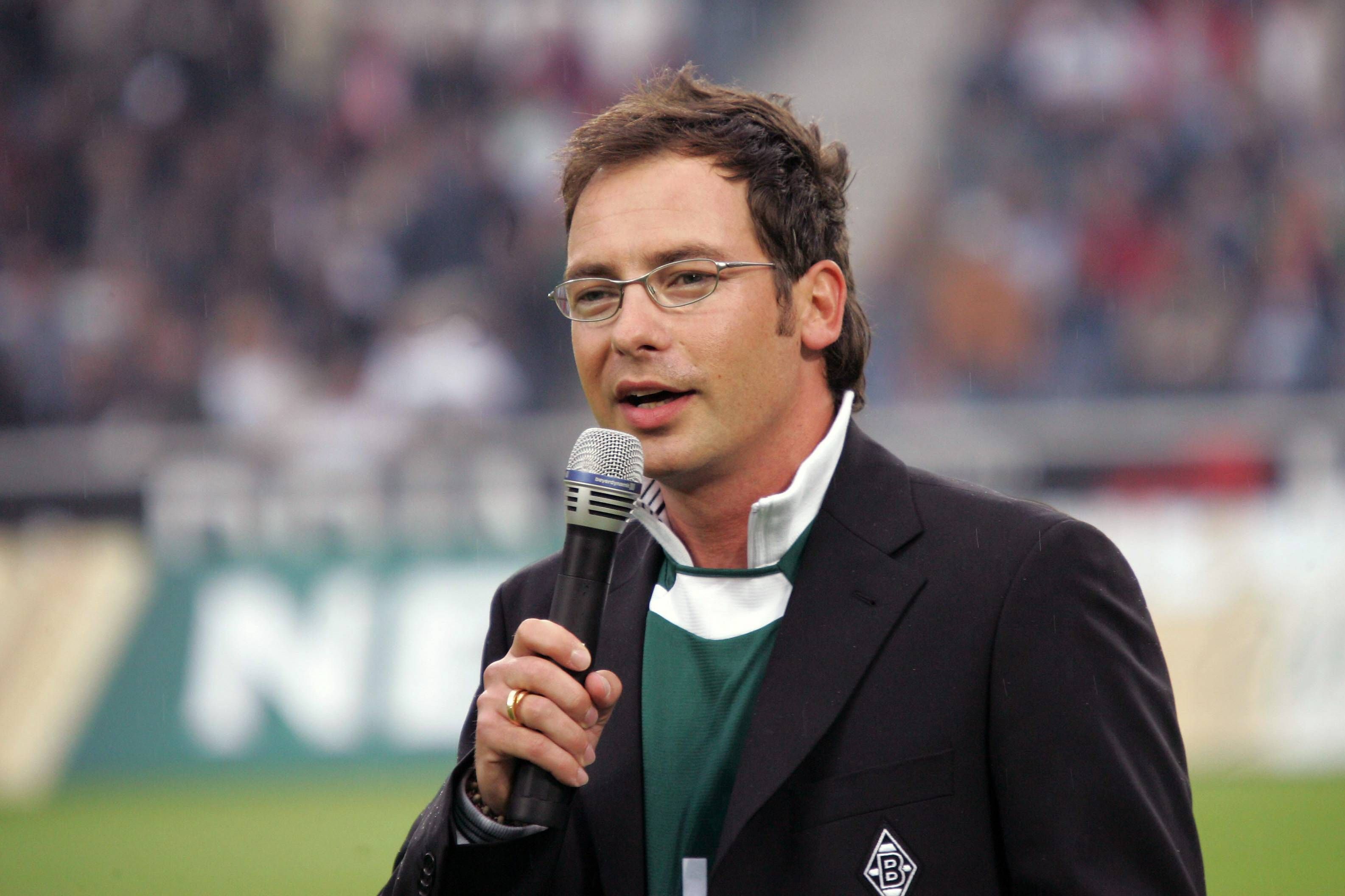 TV-Moderator Matthias Opdenhövel hat als Stadionsprecher für Fußball-Bundesligist Borussia Mönchengladbach gearbeitet. Auf diesem Bild ist der 51-Jährige am 22. Juli 2005 im Gladbacher Stadion zu sehen. Opdenhövel hält ein Mikrofon in der Hand.