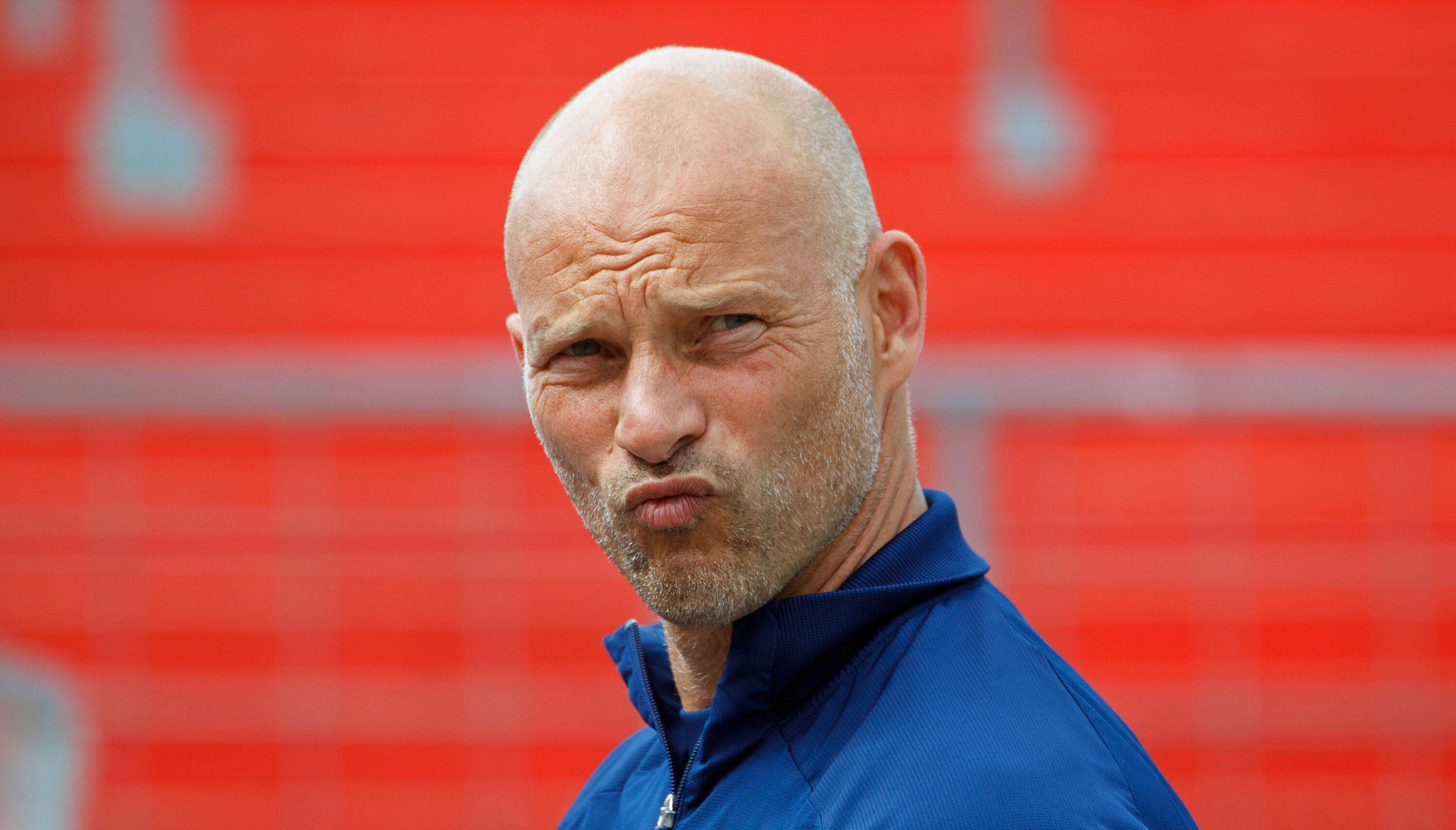 Ex-Gladbach-Profi und -Trainer Arie van Lent, hier zu sehen am 11. April 2021 in Unterhaching. Van Lent blickt skeptisch nach vorne.
