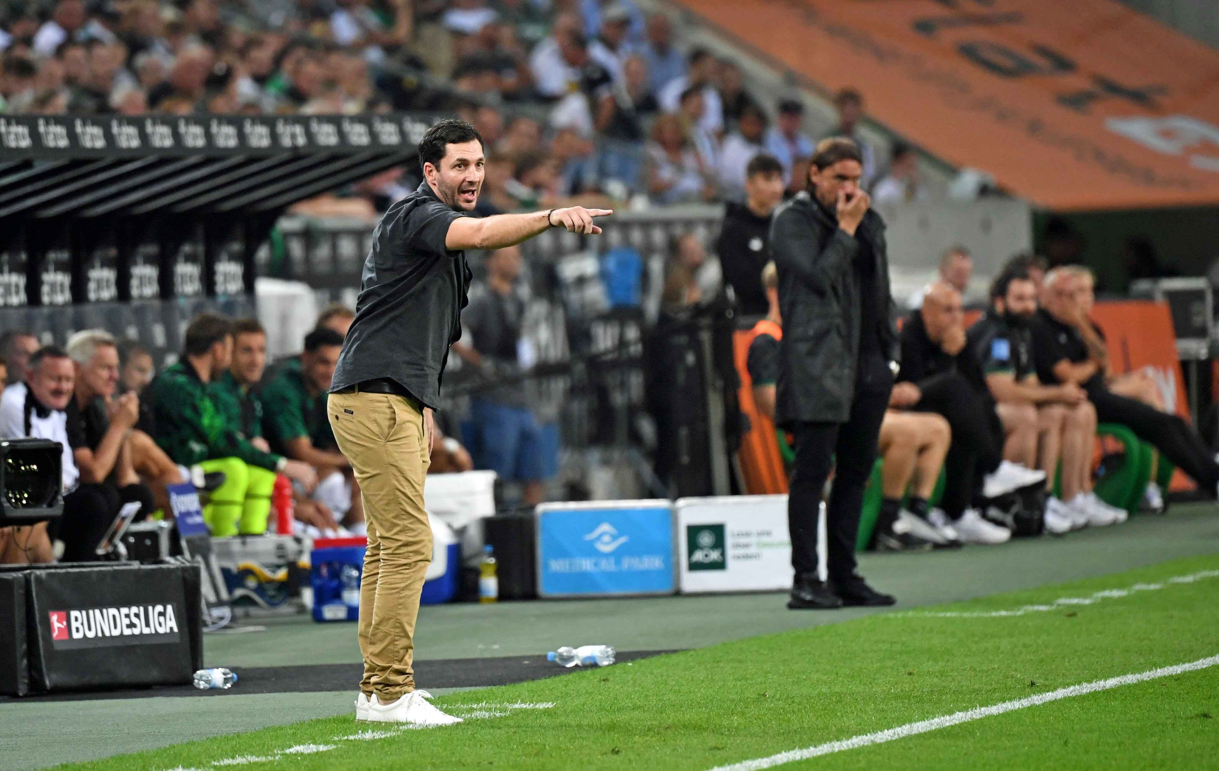Sandro Schwarz (l.), Trainer von Hertha BSC, am 19. August 2022 im Borussia-Park. Im Hintergrund ist Gladbach-Coach Daniel Farke (r.) zu sehen. Beide Trainer stehen an der Seitenlinie.