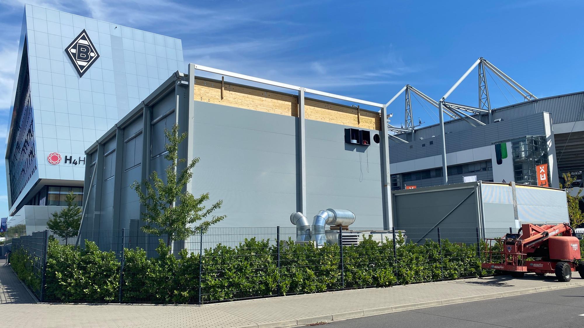 Auf dem Parkplatz P10 im Borussia-Park entsteht der neue Kraftraum für die Profis von Borussia Mönchengladbach. Im Vordergrund steht der Neubau, im Hintergrund sind das Stadion und das H-Hotel zu sehen.