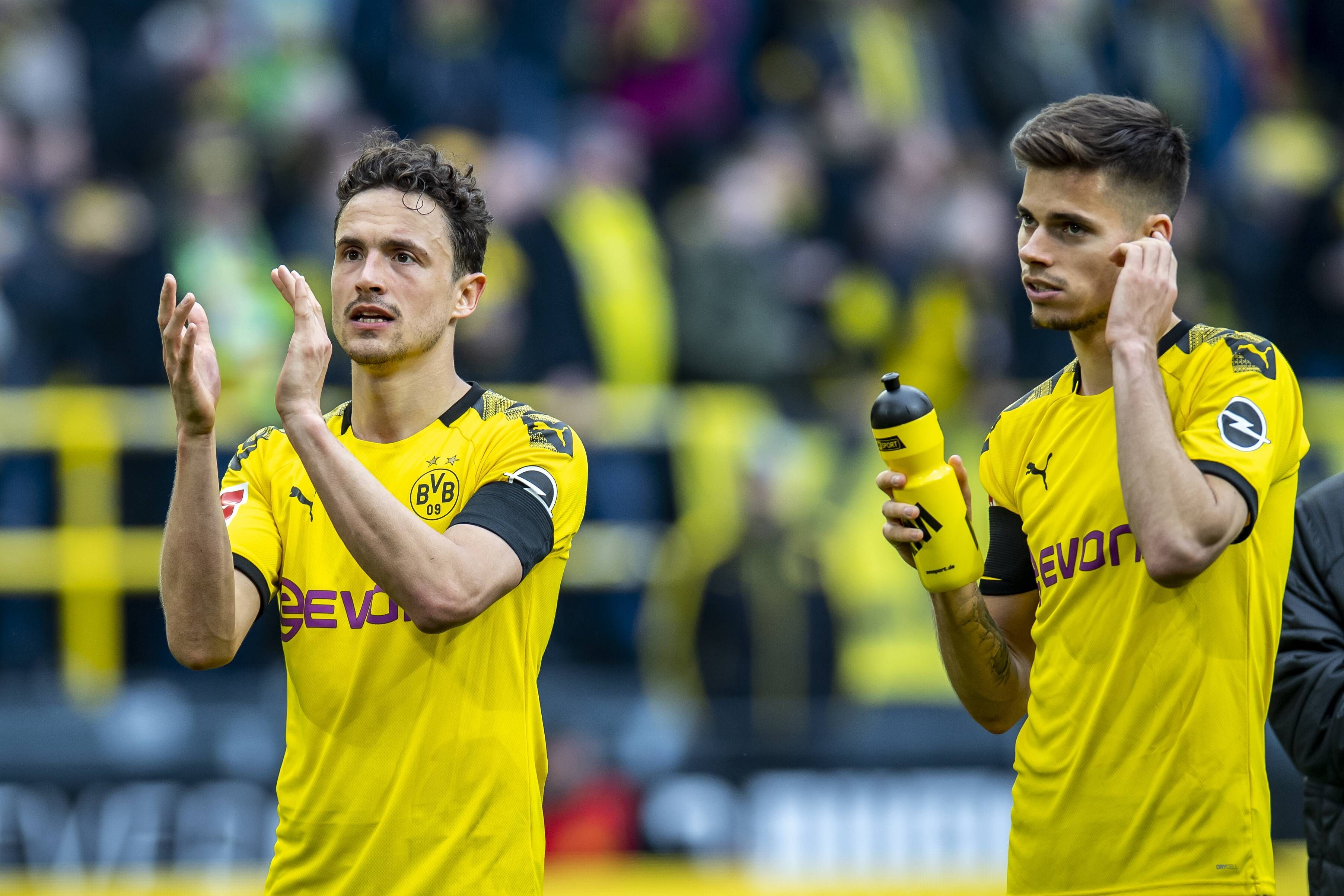 Thomas Delaney (li.) und Julian Weigl (re.) gemeinsam im Trikot von Borussia Dortmund. Das Foto stammt vom 11. Mai 2019. Delaney klatsch und bedankt sich bei den Fans, Weigl hält in der rechten Hand eine Trinkflasche.