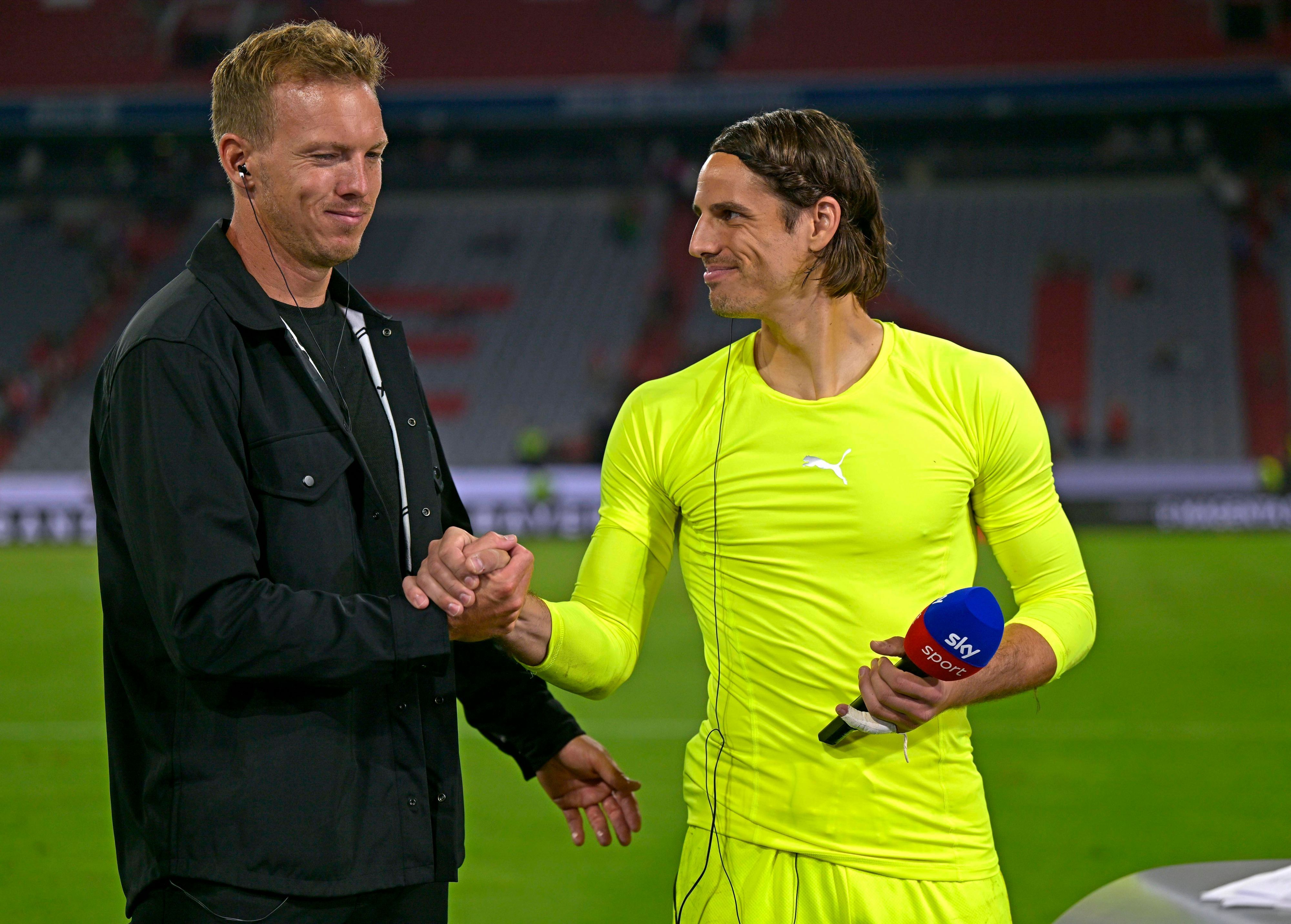 Bayern-München-Trainer Julian Nagelsmann (l.) und sein neuer Torwart Yann Sommer (r.), hier zu sehen am 28. August 2022 in der Allianz-Arena. Zu diesem Zeitpunkt hat Sommer noch bei Borussia Mönchengladbach unter Vertrag gestanden. Sommer und Nagelsmann klatschen sich ab, Sommer hält in seiner linken Hand ein Mikrofon.
