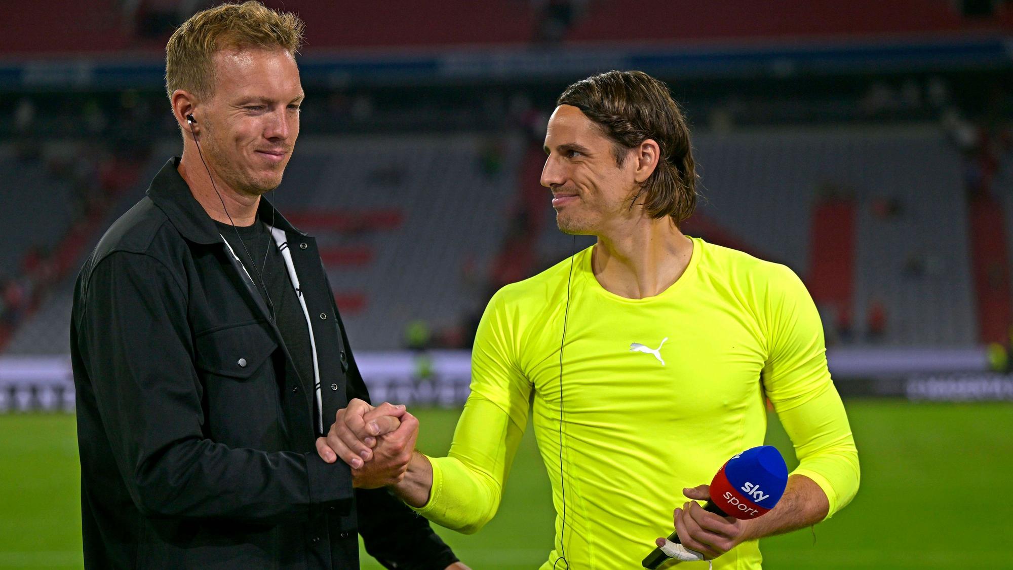 Bayern-München-Trainer Julian Nagelsmann (l.) und sein neuer Torwart Yann Sommer (r.), hier zu sehen am 28. August 2022 in der Allianz-Arena. Zu diesem Zeitpunkt hat Sommer noch bei Borussia Mönchengladbach unter Vertrag gestanden. Sommer und Nagelsmann klatschen sich ab, Sommer hält in seiner linken Hand ein Mikrofon.