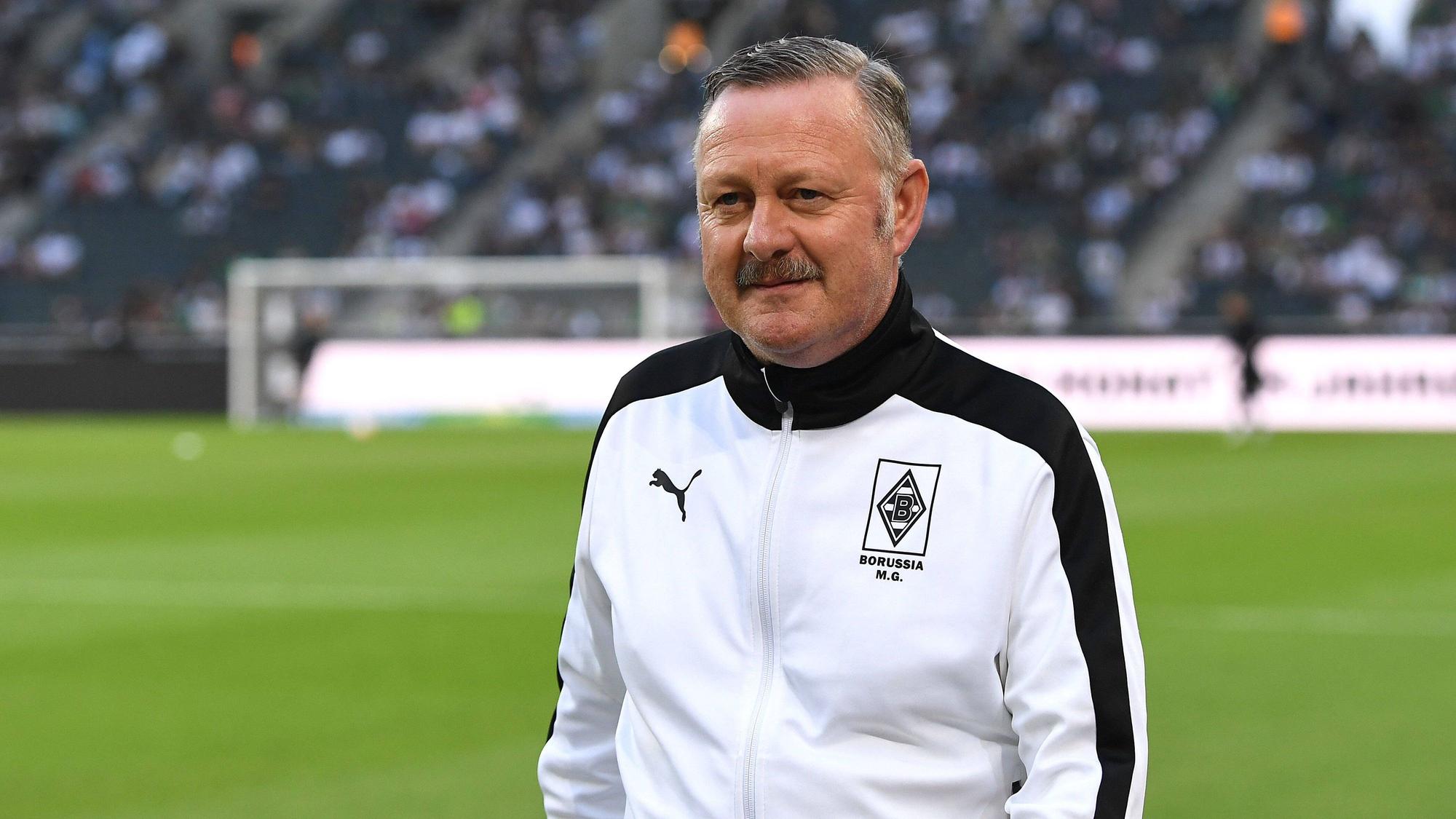 Gladbach-Manager Roland Virkus, hier am 19. August 2022 im Borussia-Park vor der Bundesliga-Partie der Fohlen-Elf gegen Hertha BSC zu sehen. Virkus trägt eine weiß-schwarze Trainingsjacke von Puma mit Borussia-Logo.