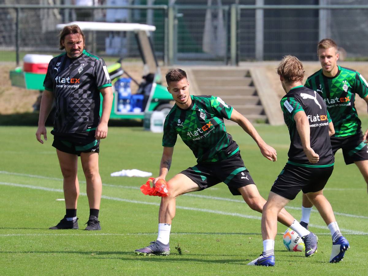 Julian Weigl (M.) im Training von Borussia Mönchengladbach am 2. September 2022 im Zweikampf mit Tony Jantschke. Im Hintergrund schauen Patrick Herrmann und Trainer Daniel Farke zu.