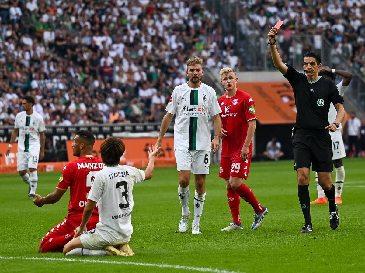 Schiedsrichter Deniz Aytekin (r.) zeigt Gladbach-Verteidiger Ko Itakura (kniend, im weißen Trikot) die Rote Karte nach einer Notbremse im Bundesliga-Duell gegen Mainz 05 (4. September 2022) im Borussia-Park. Aytekin hält die Rote Karte in der Hand.