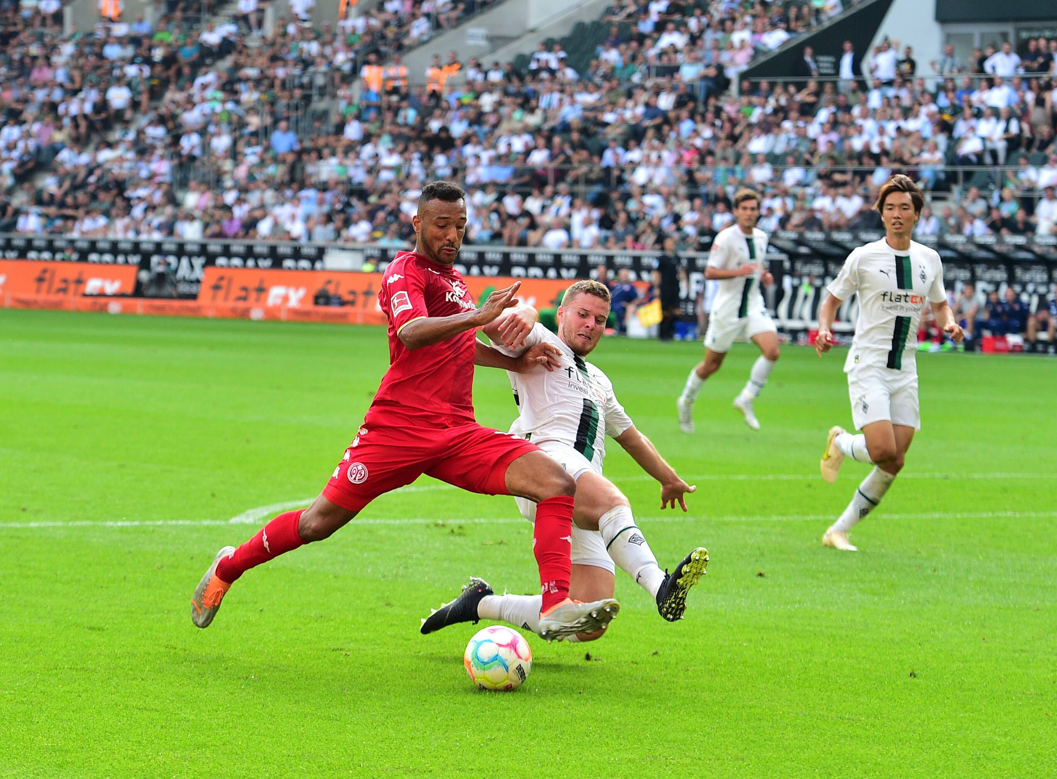 Gladbach-Verteidiger Nico Elvedi (r.) im Zweikampf mit dem Mainzer Karim Onisiwo (l.) im Bundesliga-Duell am 4. September 2022 im Borussia-Park. Elvedi setzt zur Grätsche an.