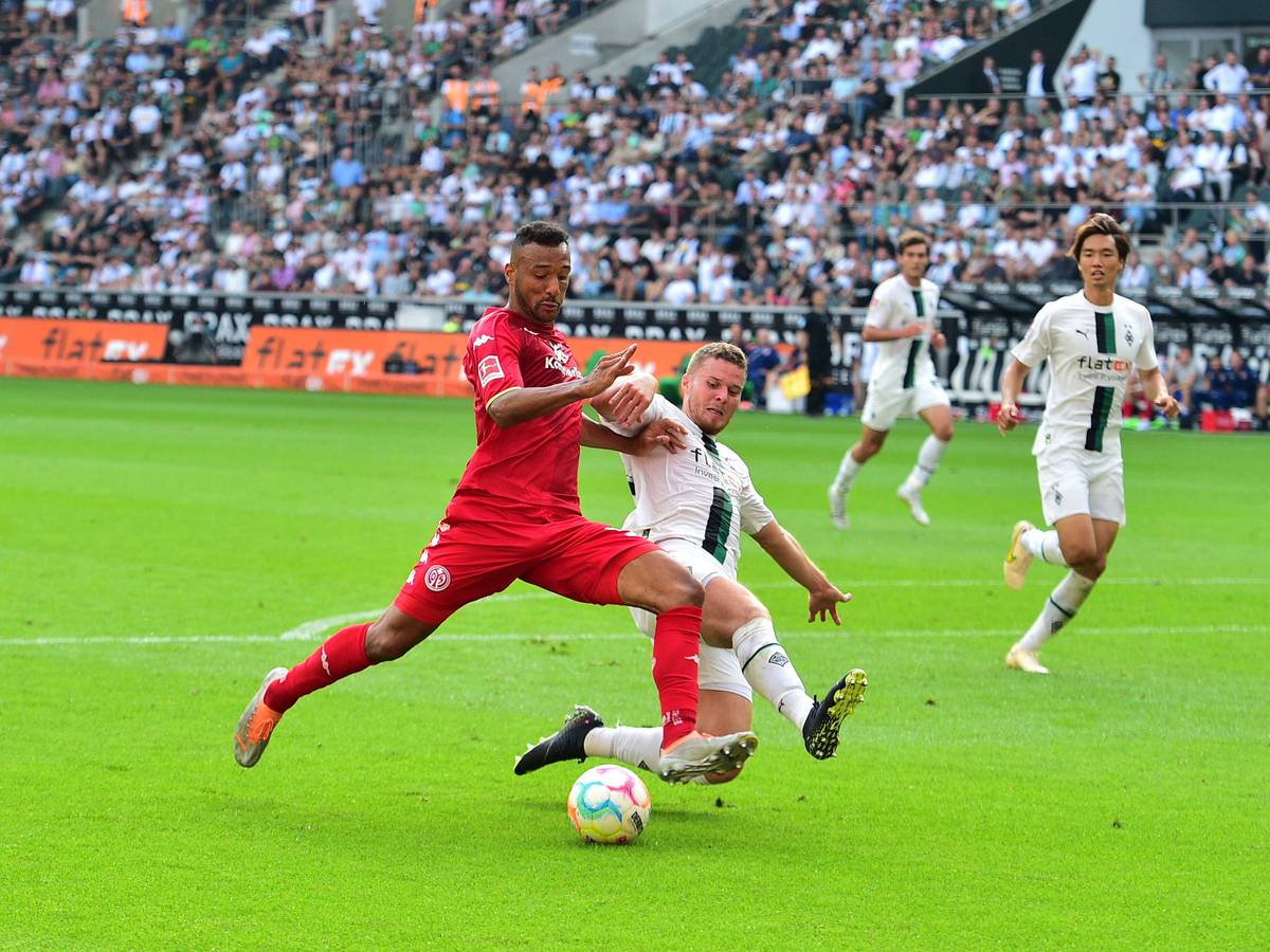 Gladbach-Verteidiger Nico Elvedi (r.) im Zweikampf mit dem Mainzer Karim Onisiwo (l.) im Bundesliga-Duell am 4. September 2022 im Borussia-Park. Elvedi setzt zur Grätsche an.