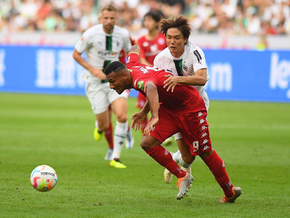 Notbremse! In dieser Szene holt sich Gladbach-Verteidiger Ko Itakura (r.) im Zweikampf mit dem Mainzer Karim Onisiwo die Rote Karte ab während des Bundesliga-Duells am Sonntag (4. September 2022) im Borussia-Park. Itakura hält seinen Gegenspieler fest.