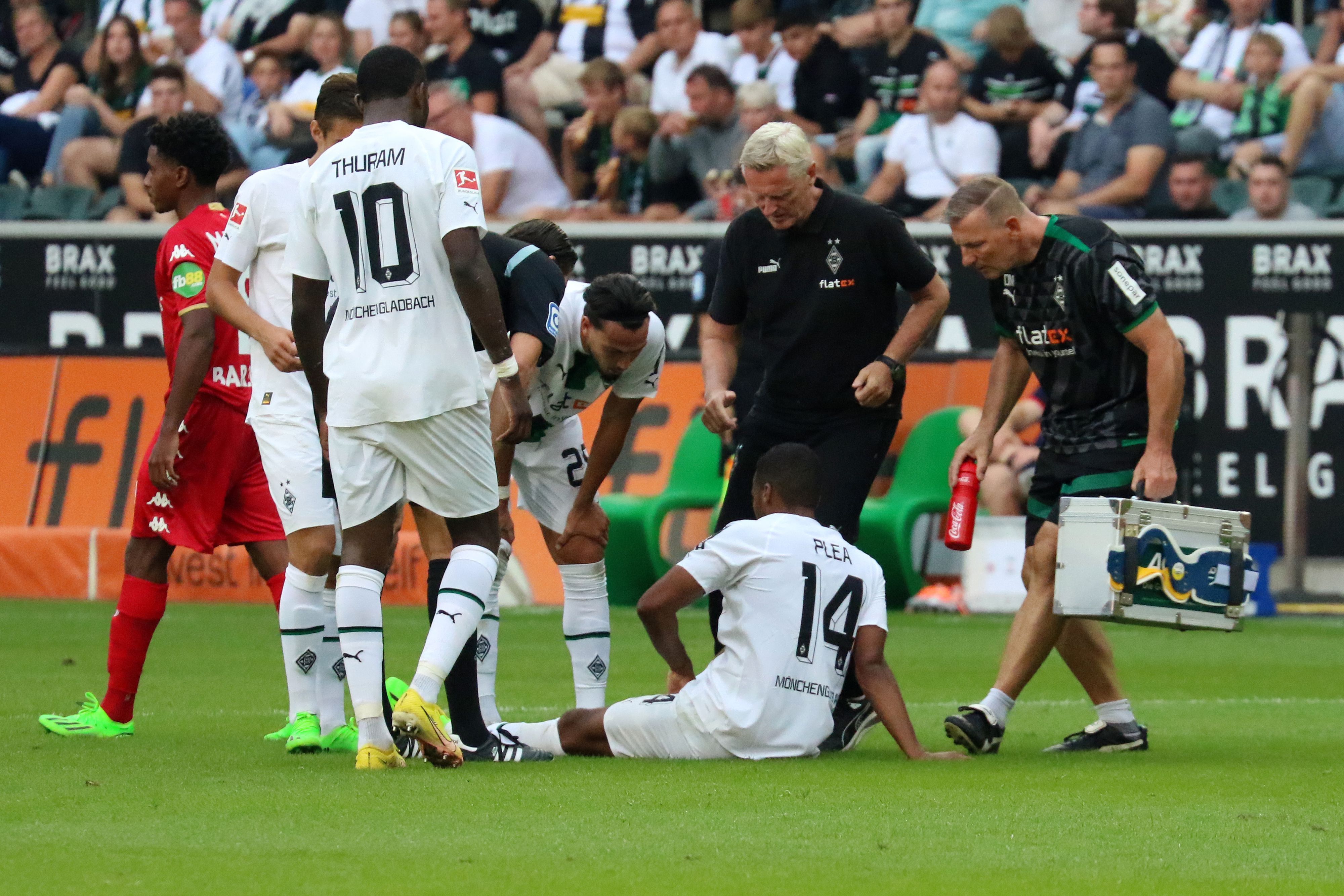Alassane Plea sitzt angeschlagen auf dem Rasen des Borussia-Parks. Der Franzose musste das Bundesliga-Match gegen Mainz (4. September 2022) vorzeitig verletzt beenden. Der Mannschafts-Arzt eilt zur Hilfe.