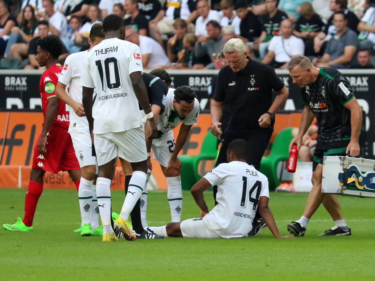 Alassane Plea sitzt angeschlagen auf dem Rasen des Borussia-Parks. Der Franzose musste das Bundesliga-Match gegen Mainz (4. September 2022) vorzeitig verletzt beenden. Der Mannschafts-Arzt eilt zur Hilfe.