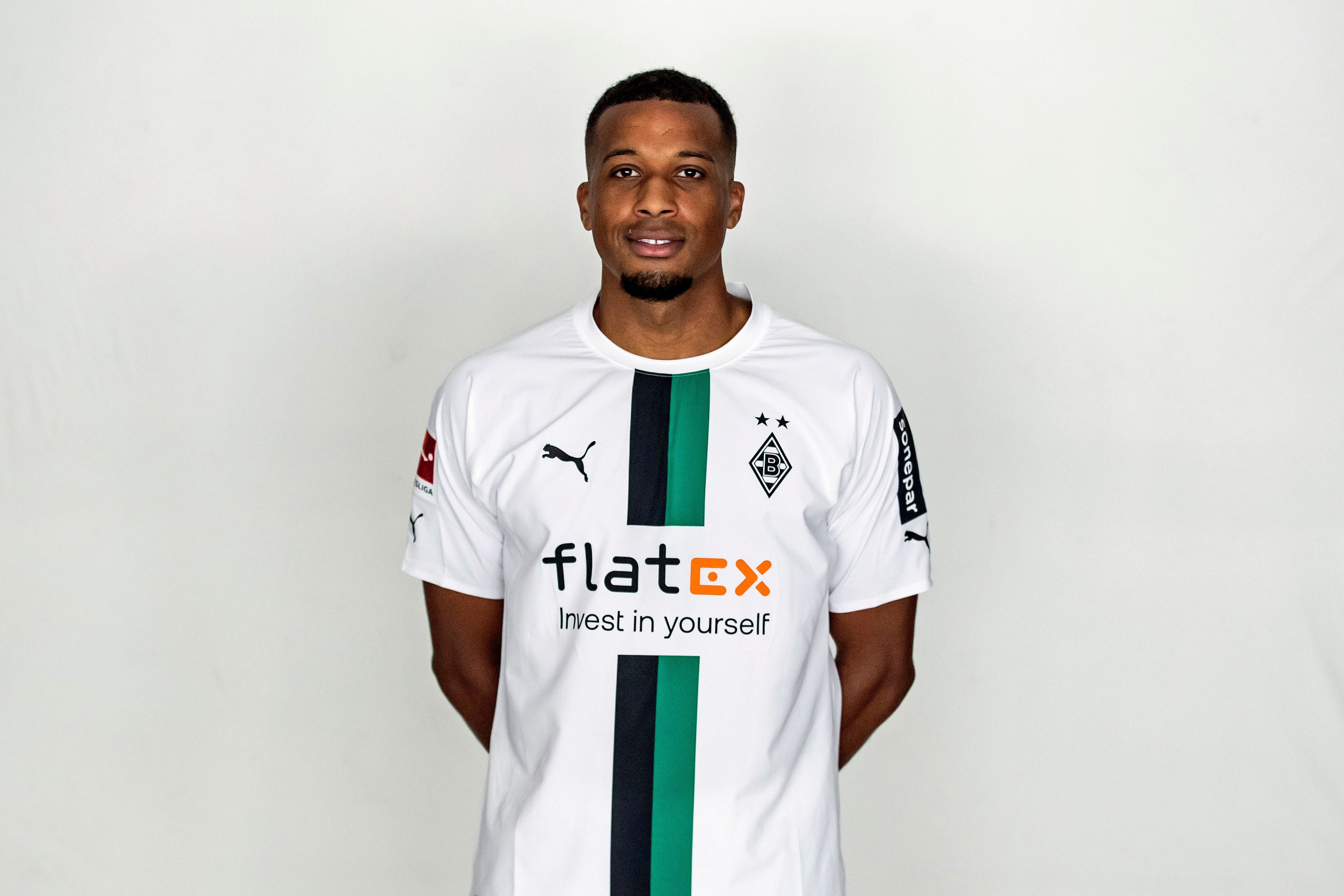 Alassane Plea, Stürmer bei  Fußball-Bundesligist Borussia Mönchengladbach in der Saison 2022/2023. Er hat die Arme hinter seinem Rücken verschränkt.