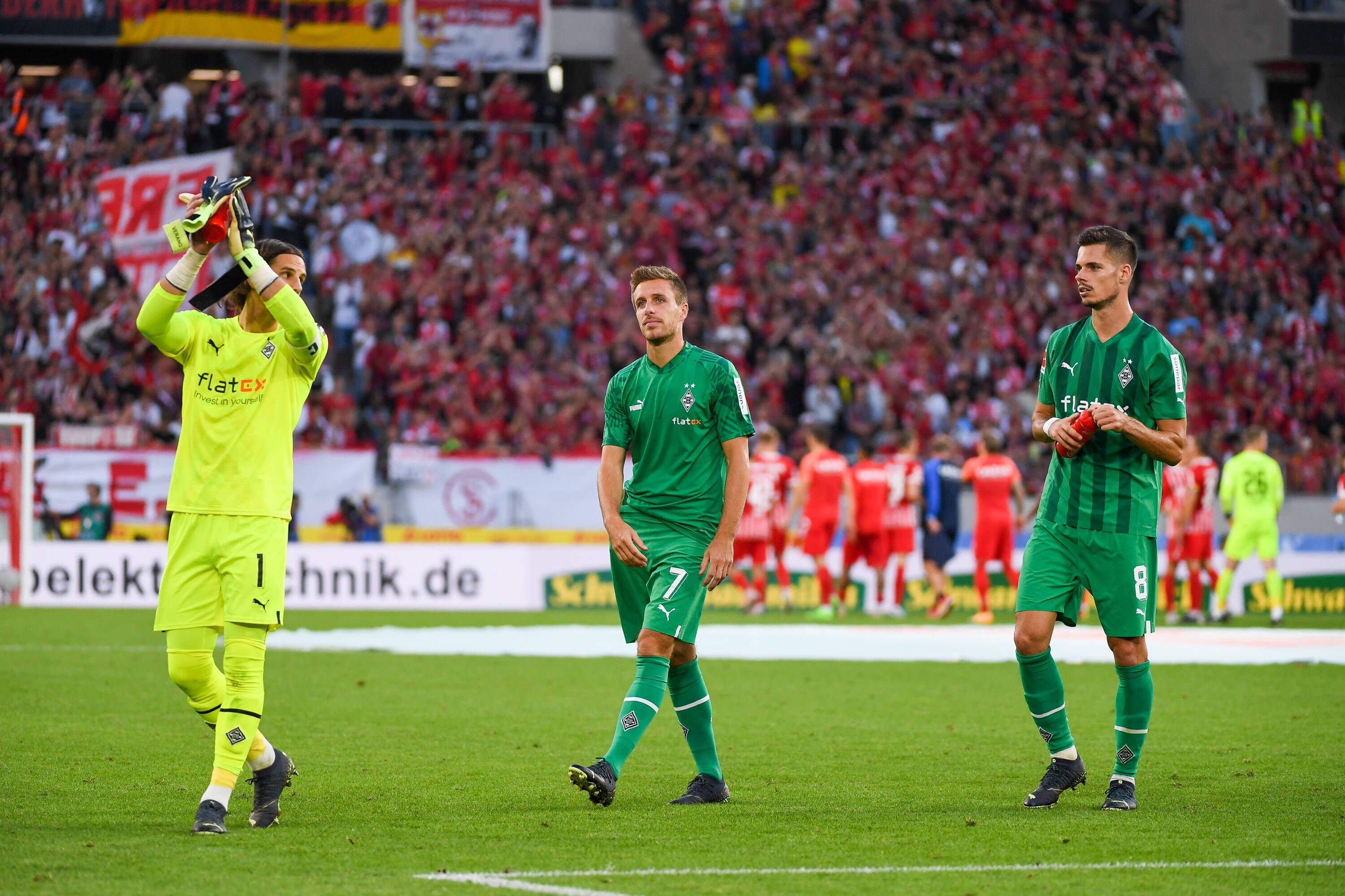 Yann Sommer (l.), Patrick Herrmann (Mitte) und Julian Weigl applaudieren am 11. September 2022 nach dem Match beim SC Freiburg den Fans.