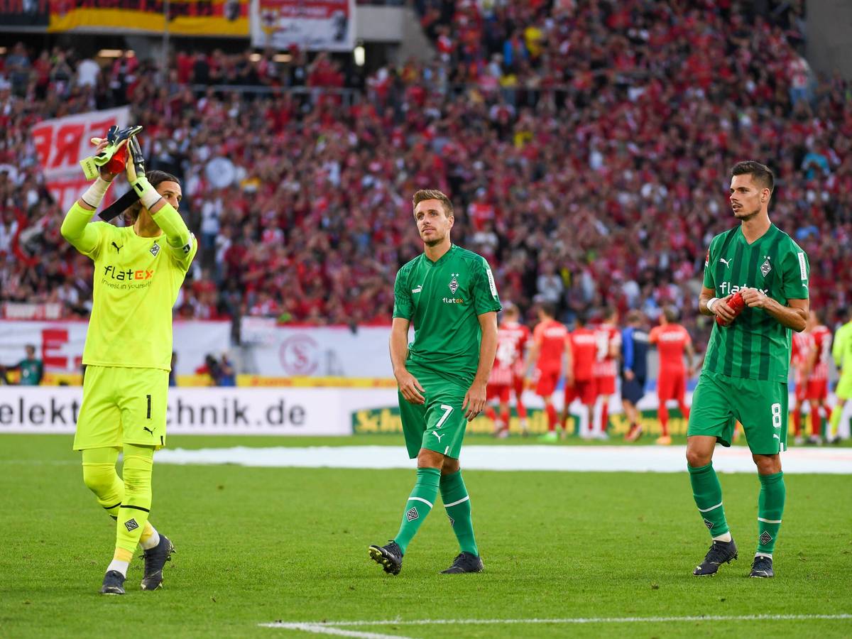 Yann Sommer (l.), Patrick Herrmann (Mitte) und Julian Weigl applaudieren am 11. September 2022 nach dem Match beim SC Freiburg den Fans.