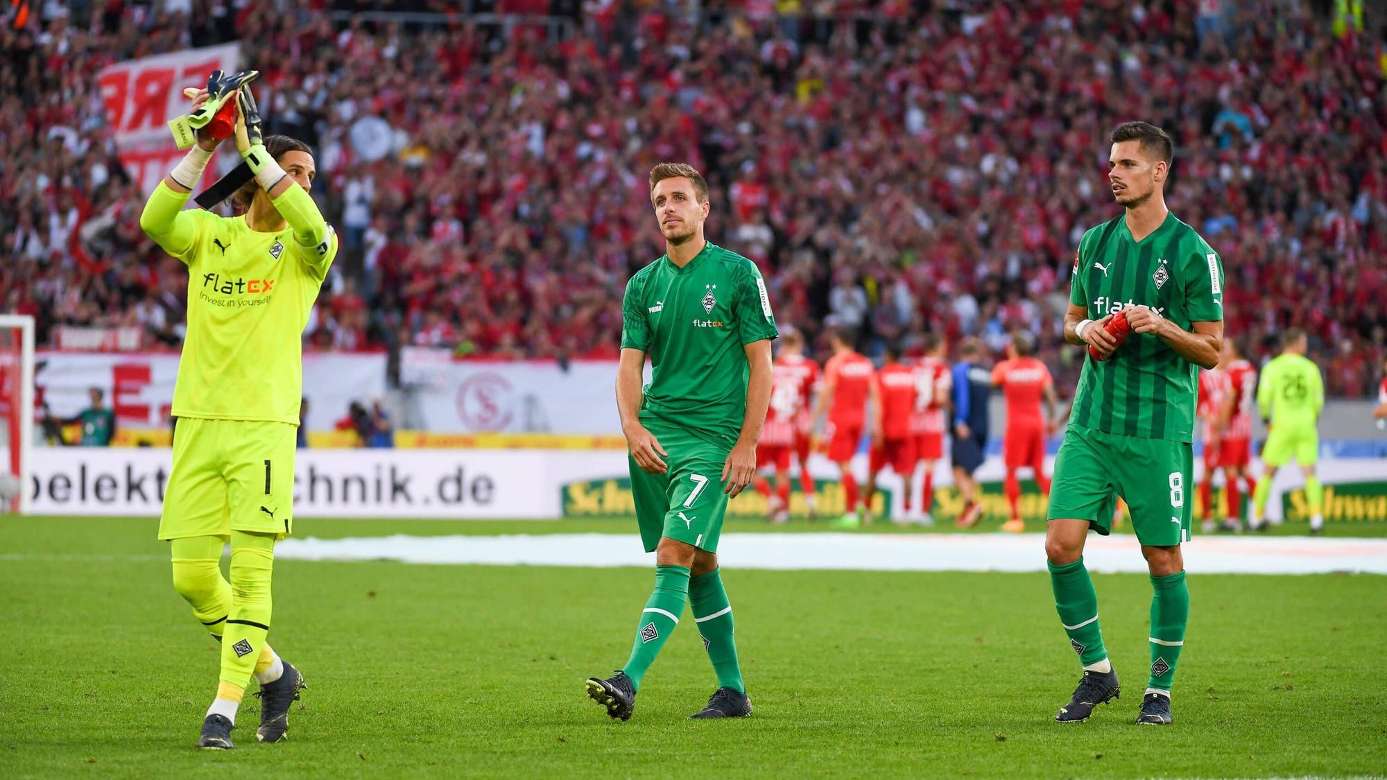 Yann Sommer (l.), Patrick Herrmann (Mitte) und Julian Weigl applaudieren am 11. September 2022 nach dem Match beim SC Freiburg den Fans.