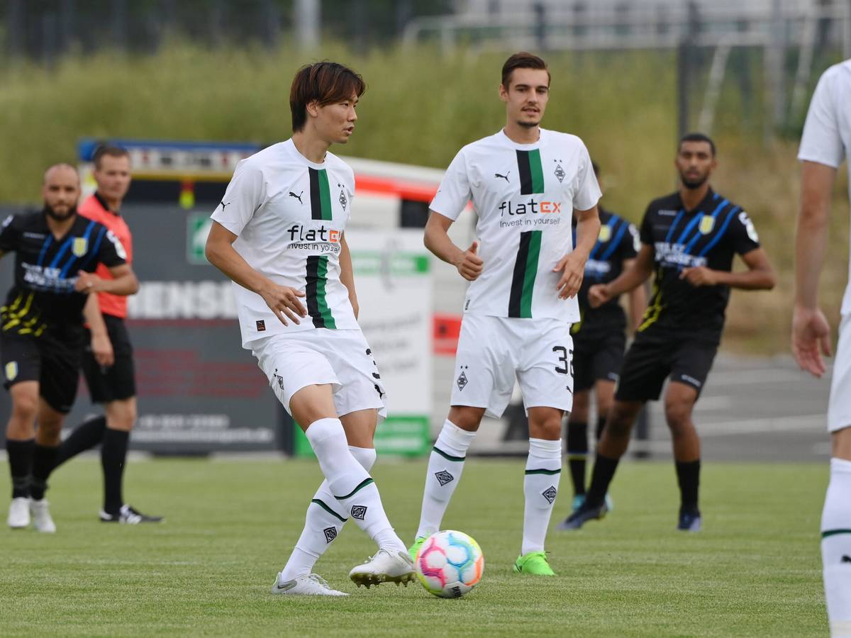 Die Gladbach-Profis Ko Itakura (l.) und Florian Neuhaus (r.) haben sich schwere Knieverletzungen zugezogen. Auf diesem Foto sind die beiden am 20. Juli 2022 bei einem Testspiel in Velbert zu sehen. Itakura hat den Ball am Fuß, Neuhaus schaut zu ihm.