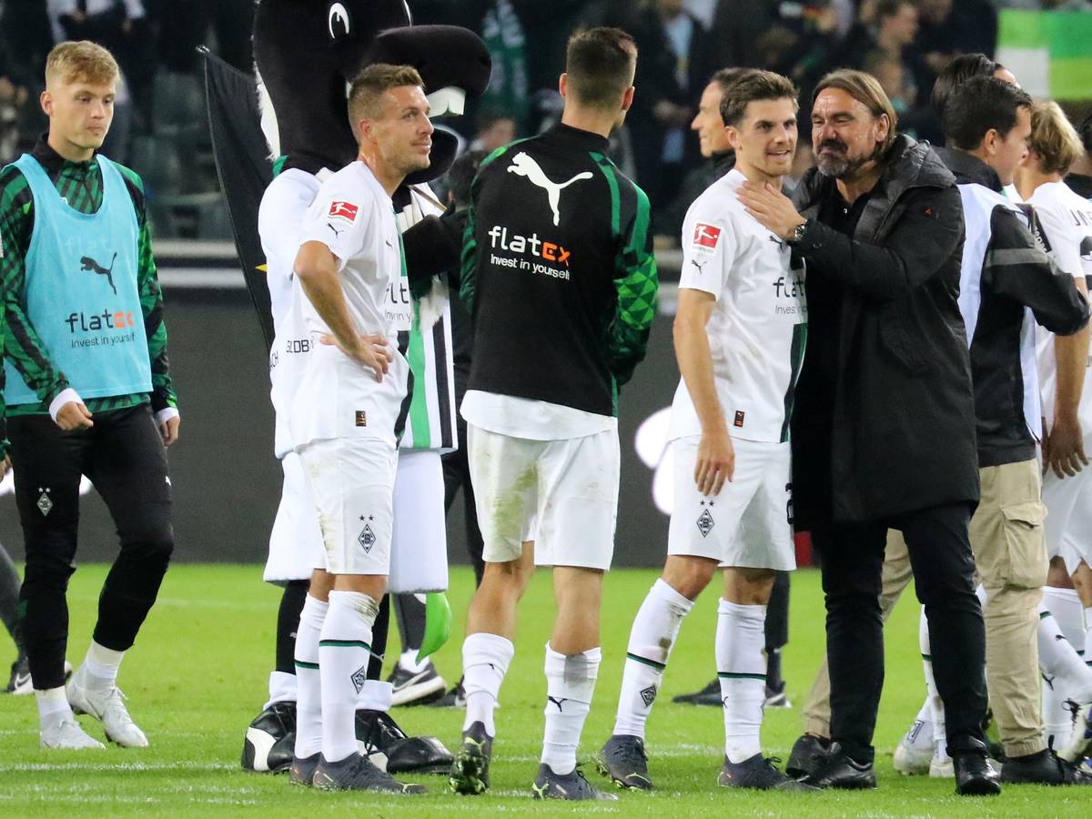 Gladbach-Trainer Daniel Farke mit seinem Matchwinner Jonas Hofmann nach der 3:0-Gala gegen RB Leipzig im Bundesliga-Topspiel am Samstag (17. September 2022) im Borussia-Park. Farke trägt dunkle Kleidung.