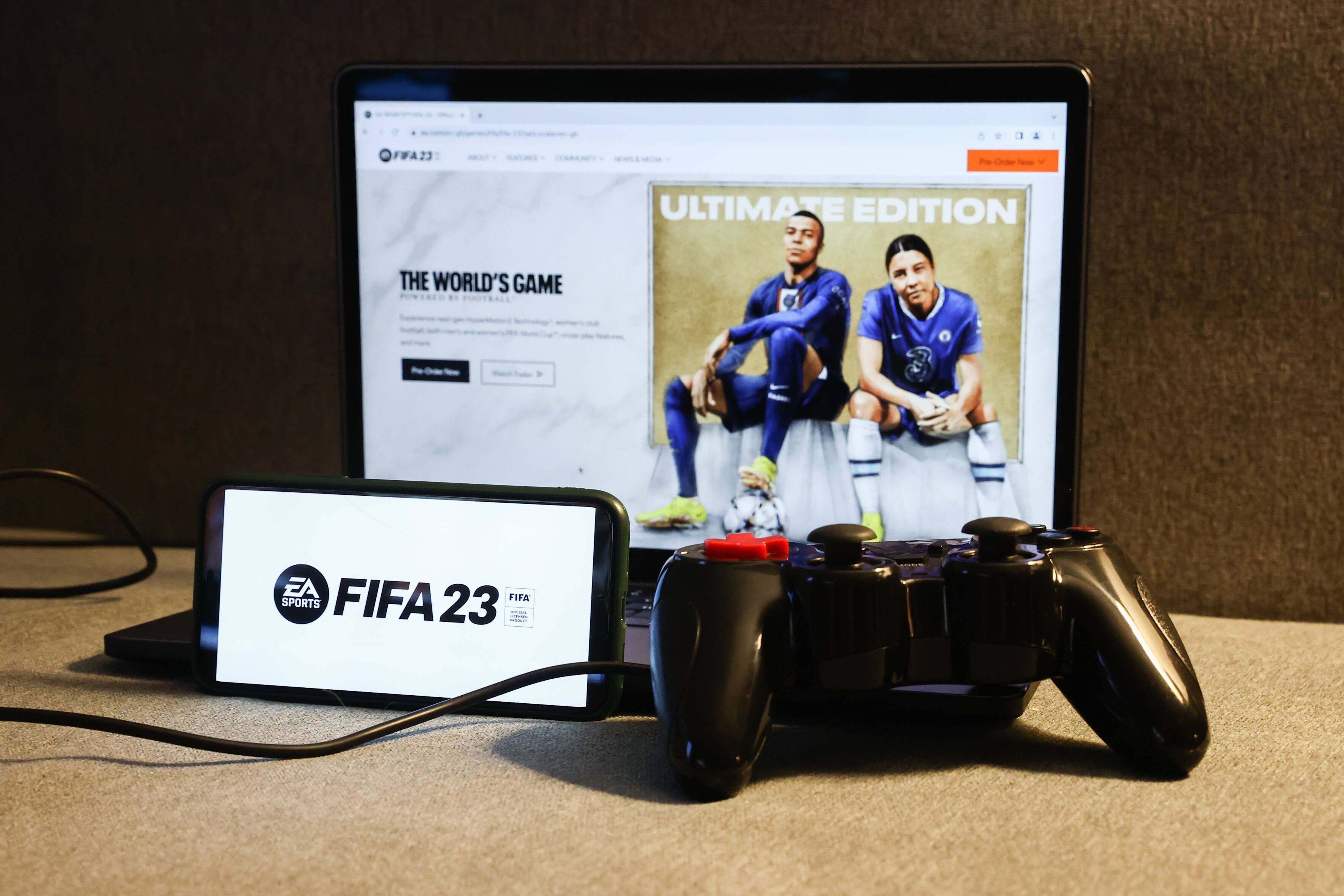 Am 27. September 2022 erscheint die neue Version des Konsolen-Klassikers FIFA. Auf dem Foto ist das Logo des neuen Teils auf einem Smartphone zu sehen, im Hintergrund zeigt ein Laptop das voraussichtliche Cover.